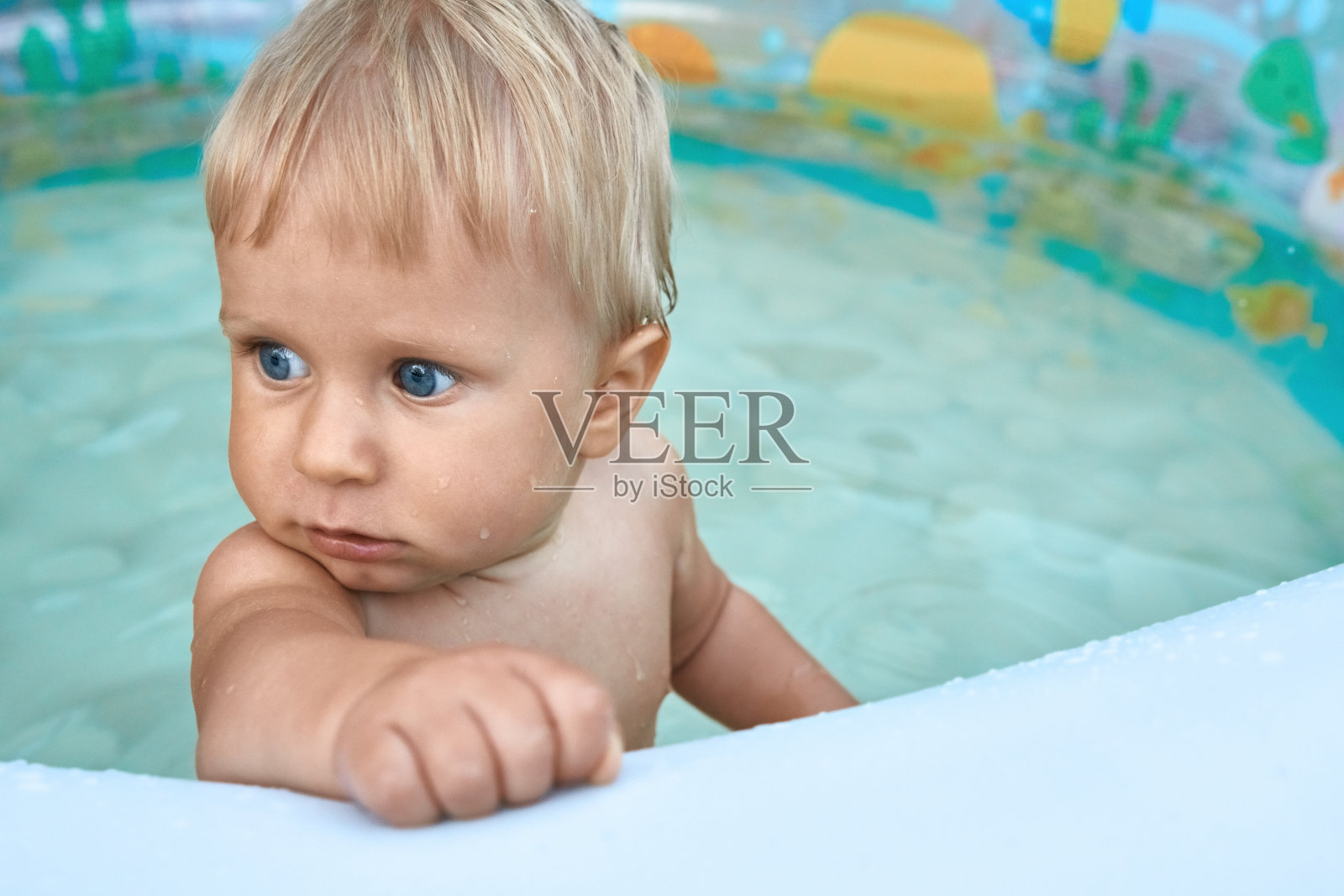 可爱的一岁婴儿站在婴儿池照片摄影图片