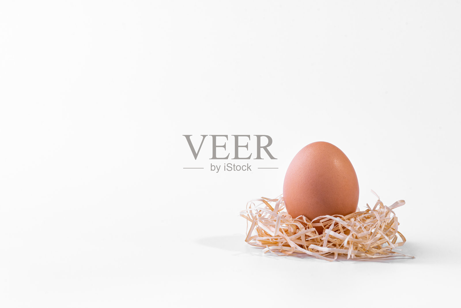 新鲜的鸡蛋在一窝稻草孤立在白色的背景照片摄影图片