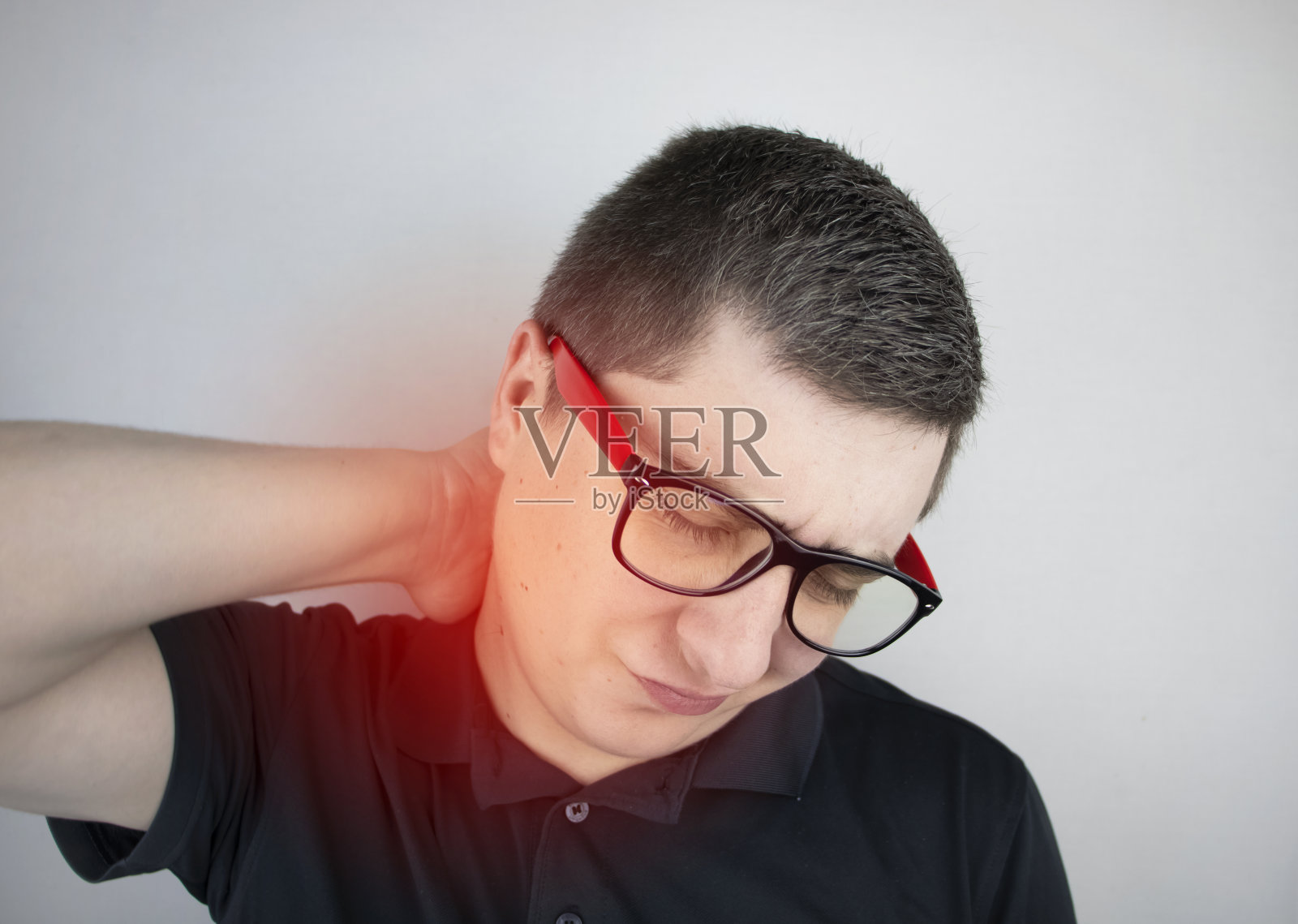 男人颈部疼痛，用手按摩颈椎。由于久坐不动的工作或身体压力造成的骨软骨病、疝或神经损伤照片摄影图片