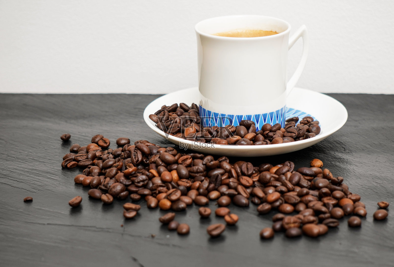 黑色背景上的咖啡杯和咖啡豆照片摄影图片