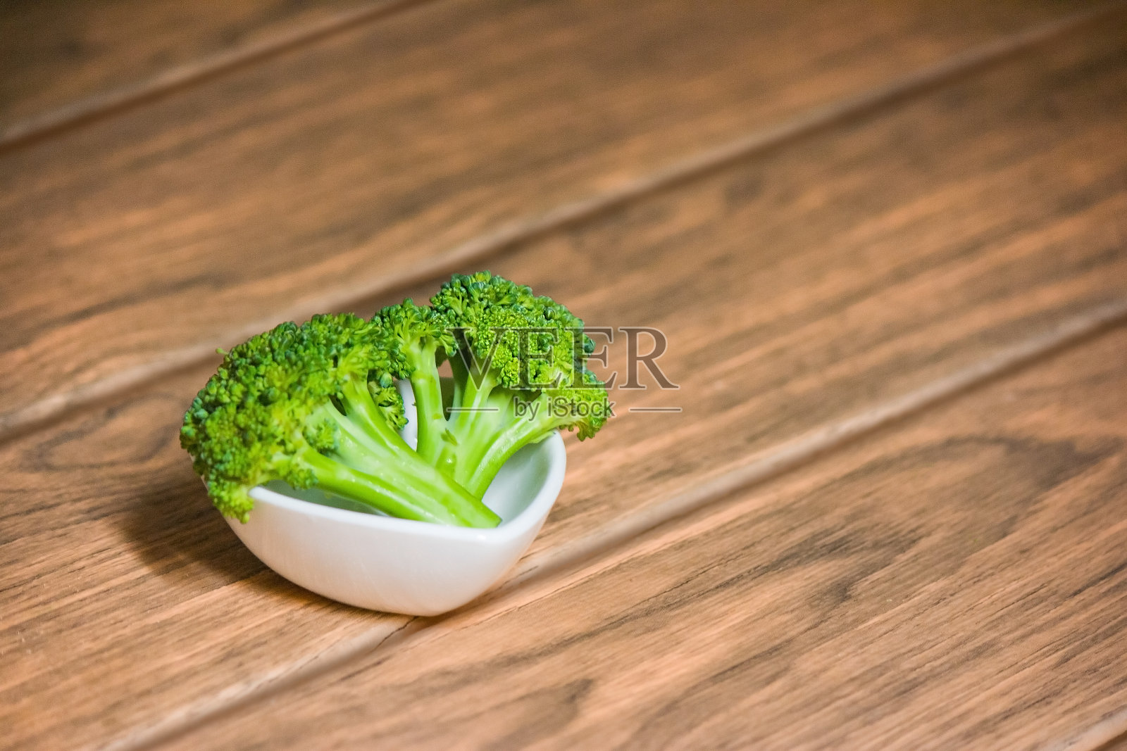 白色心形陶瓷上的一对绿色花椰菜照片摄影图片