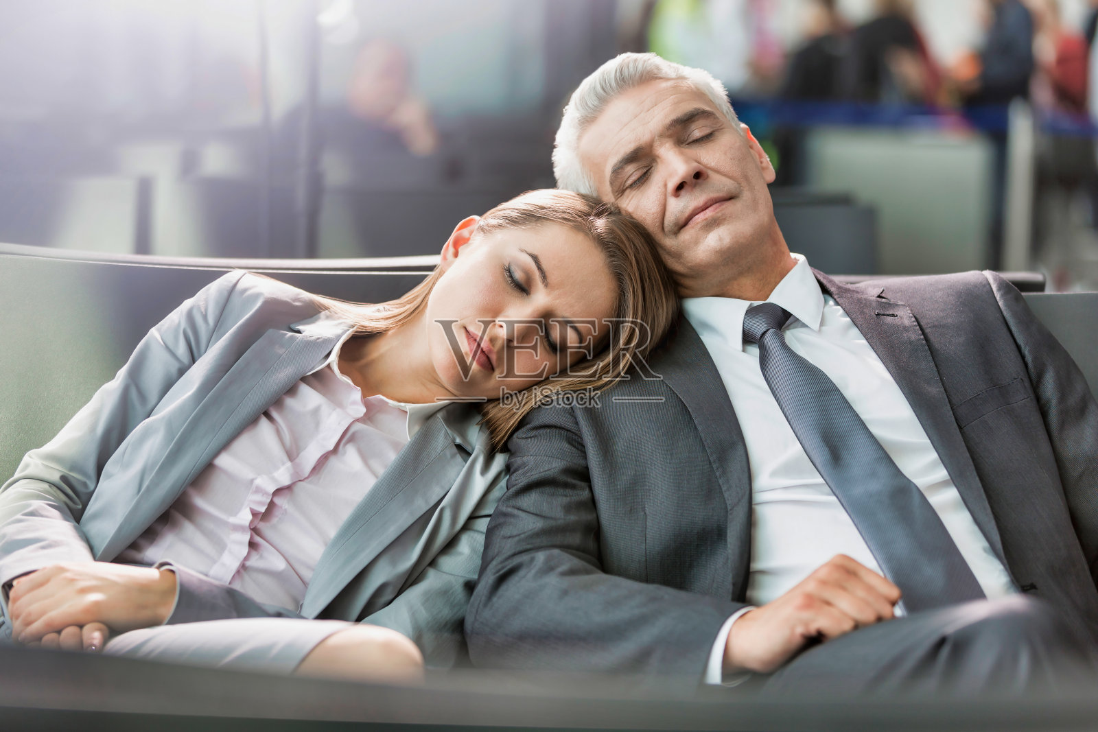 商务夫妇在机场等待登机时带着镜头光晕睡觉的照片照片摄影图片