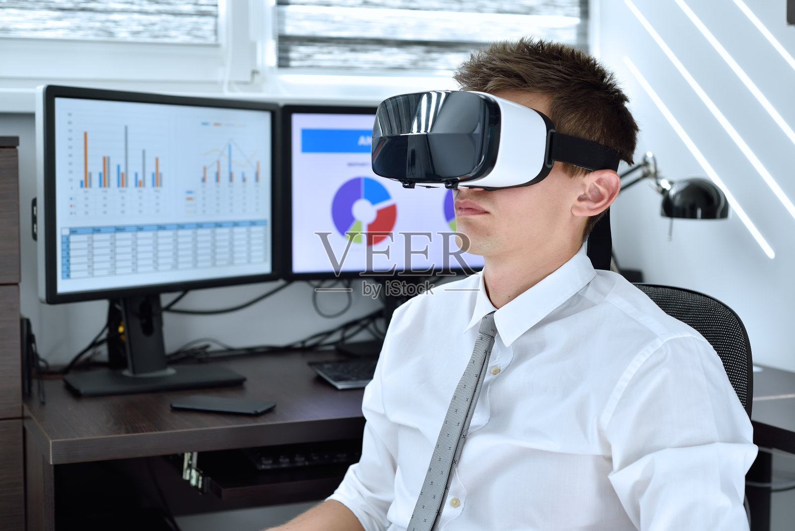 商人戴着虚拟现实眼镜在办公室工作照片摄影图片