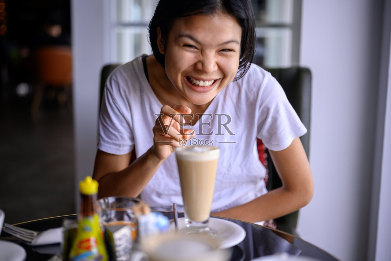 女人一边搅拌刚煮好的咖啡一边微笑照片摄影图片