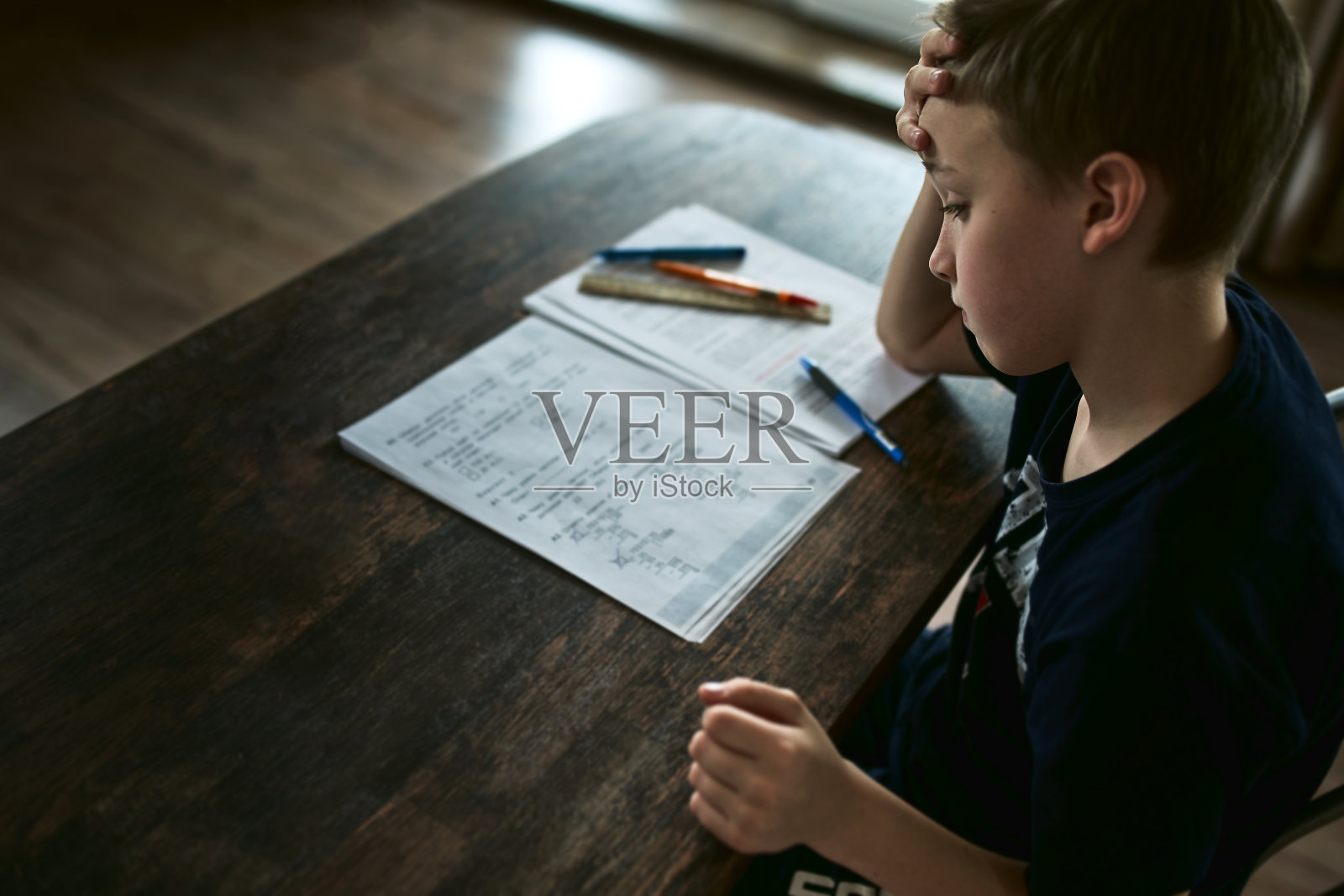 在家工作和家庭教育的概念。一个男孩正坐在他的书桌前在线学习。照片摄影图片