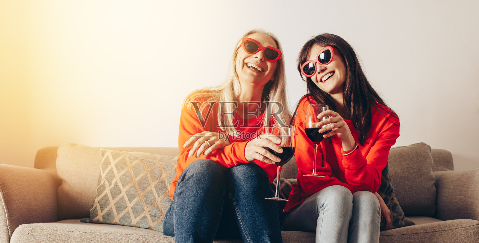微笑的母亲和女儿在家里喝葡萄酒的乐趣照片摄影图片