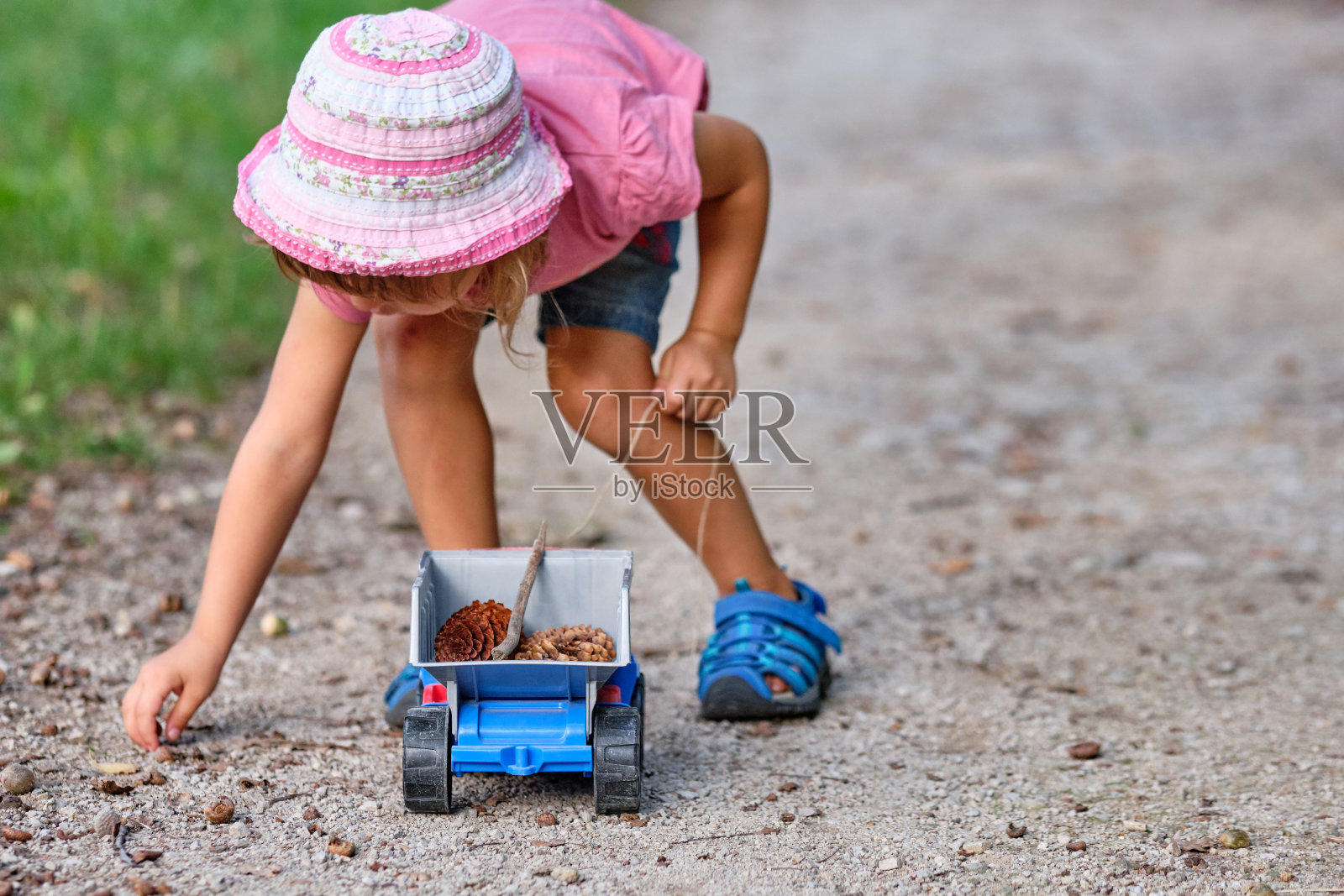 穿着夏装的小女孩和玩具卡车照片摄影图片