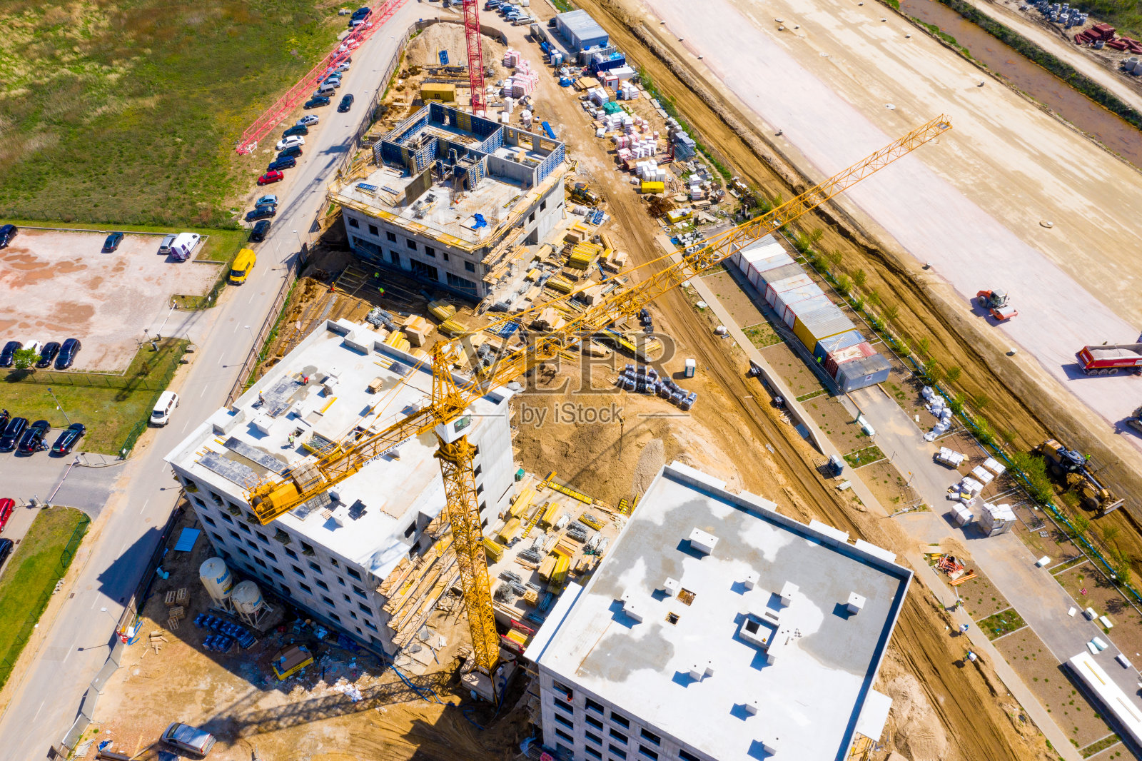 空中鸟瞰一个建筑工地的起重机向下看工业机械区周围的住宅城市公寓照片摄影图片