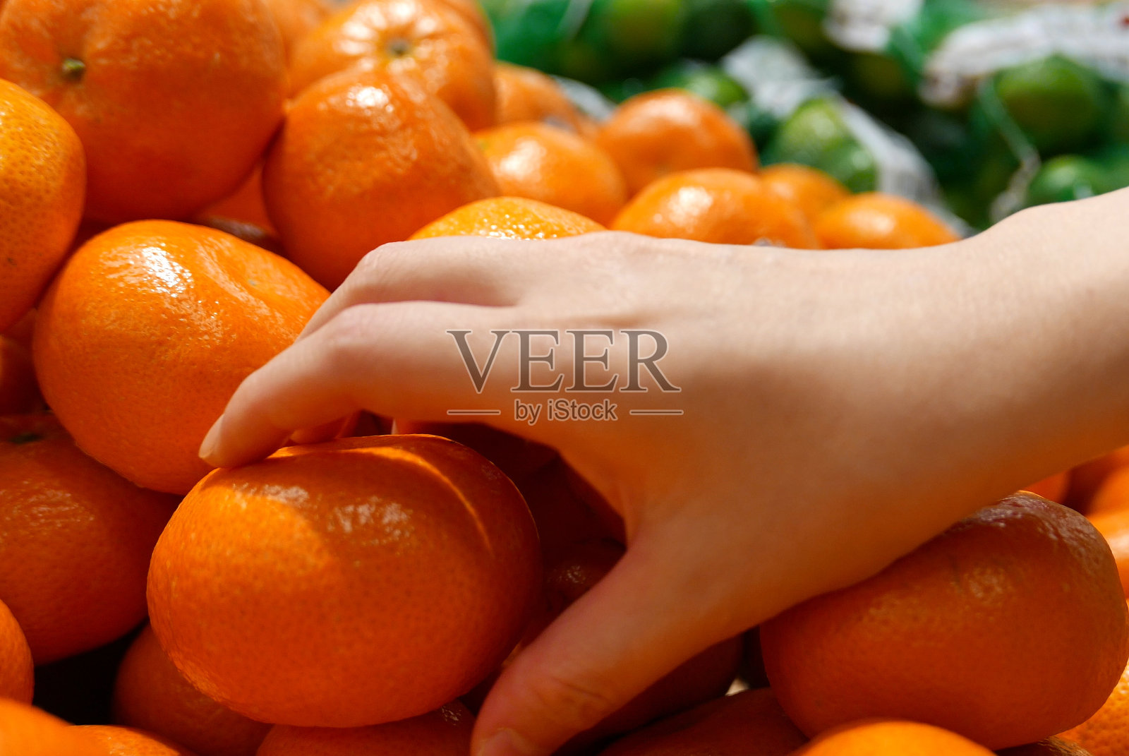 超市里女人采摘橘子的动作照片摄影图片