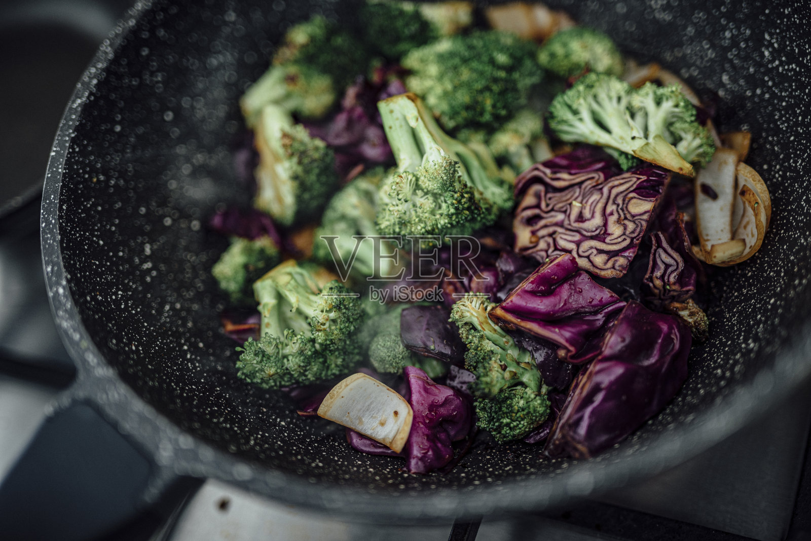 新鲜的花椰菜和紫甘蓝蒸后与亚洲香料一起食用。健康的素食食谱。照片摄影图片