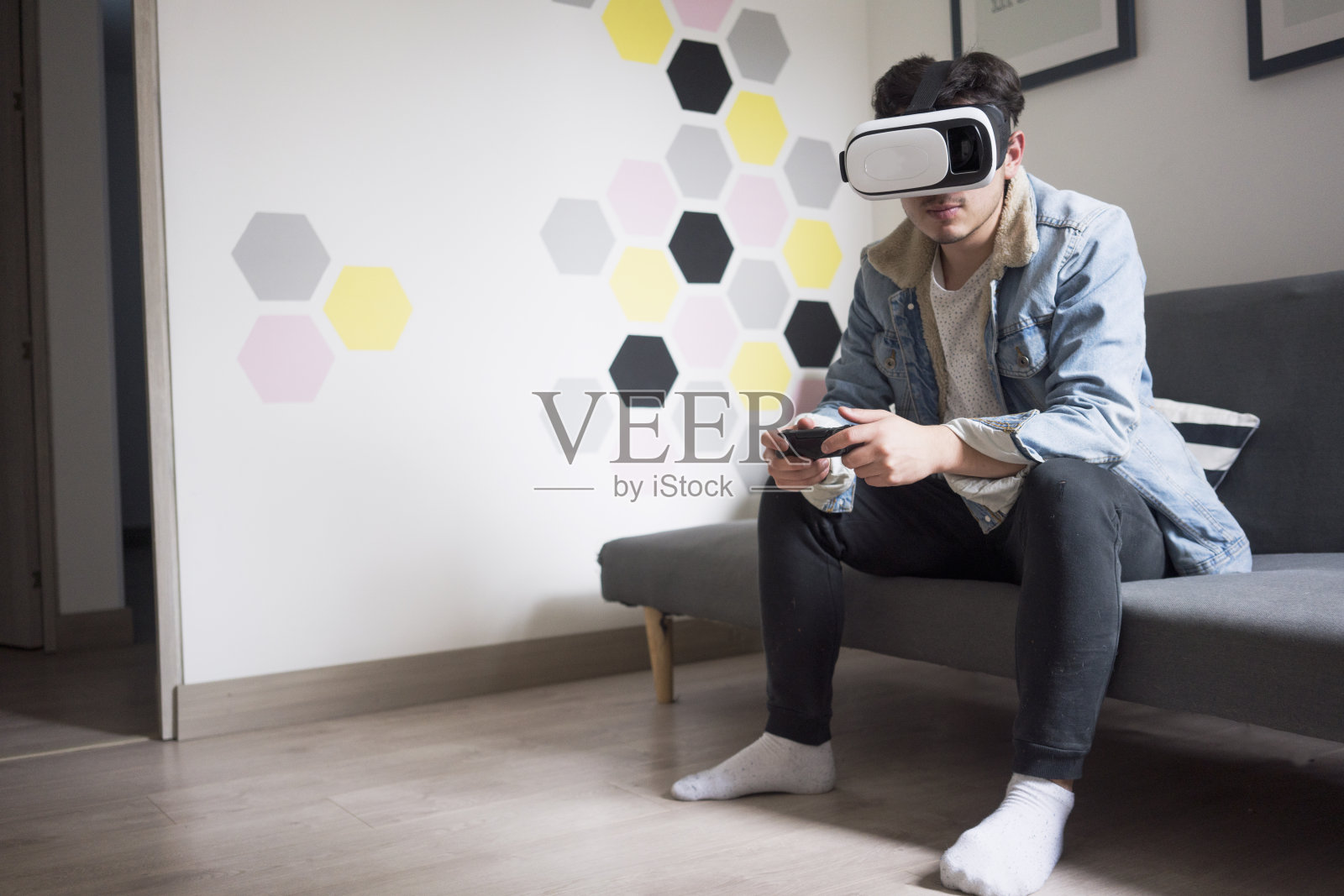年轻人戴着虚拟现实眼镜玩游戏照片摄影图片