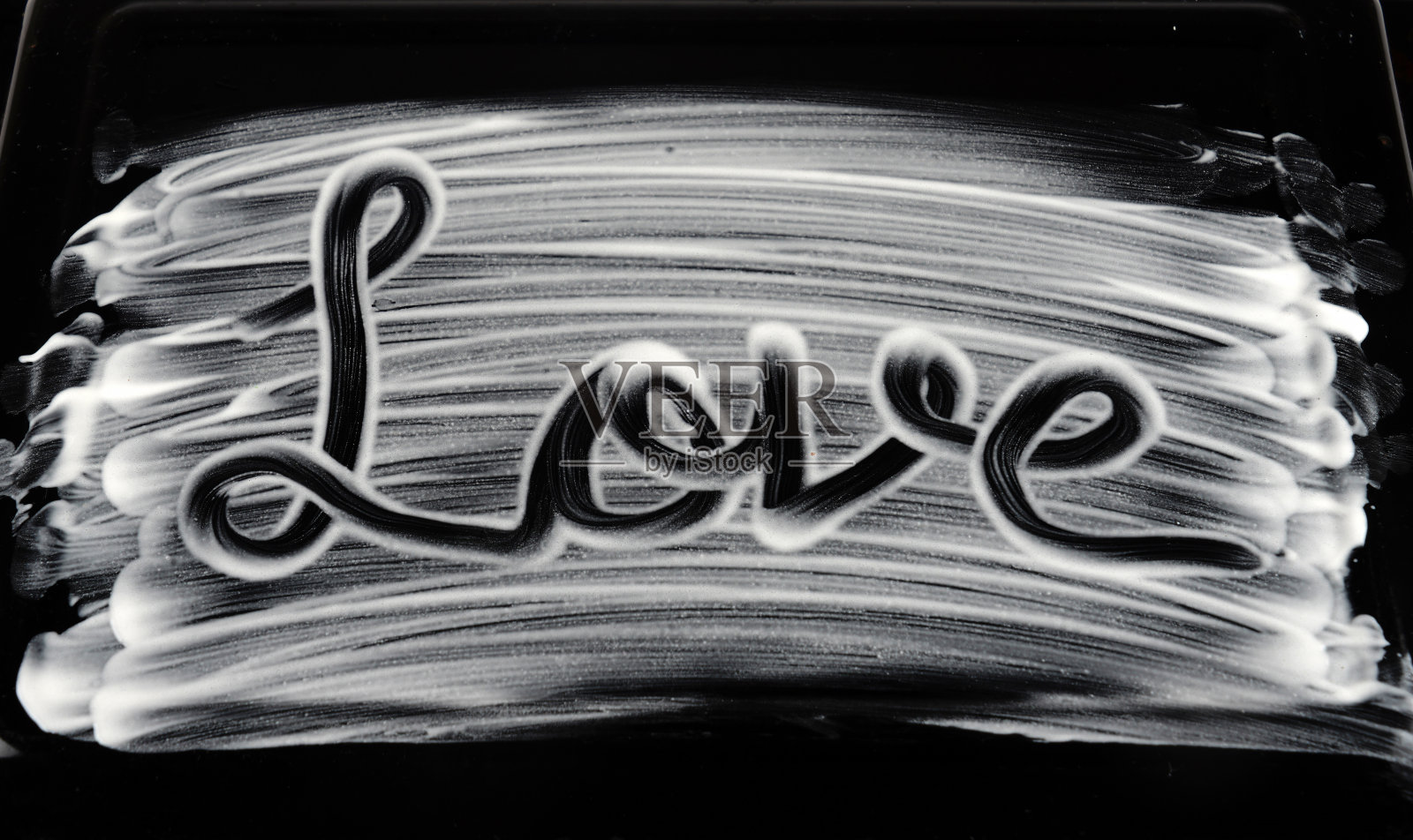 手写的爱的拼写与奶油在黑色的背景照片摄影图片