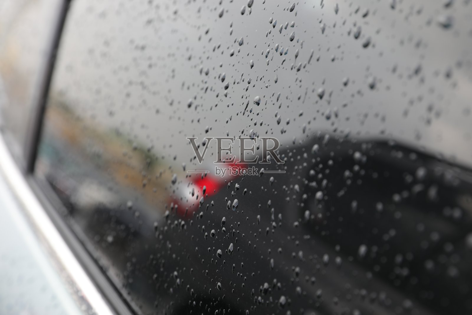 雨点落在汽车玻璃上。照片摄影图片