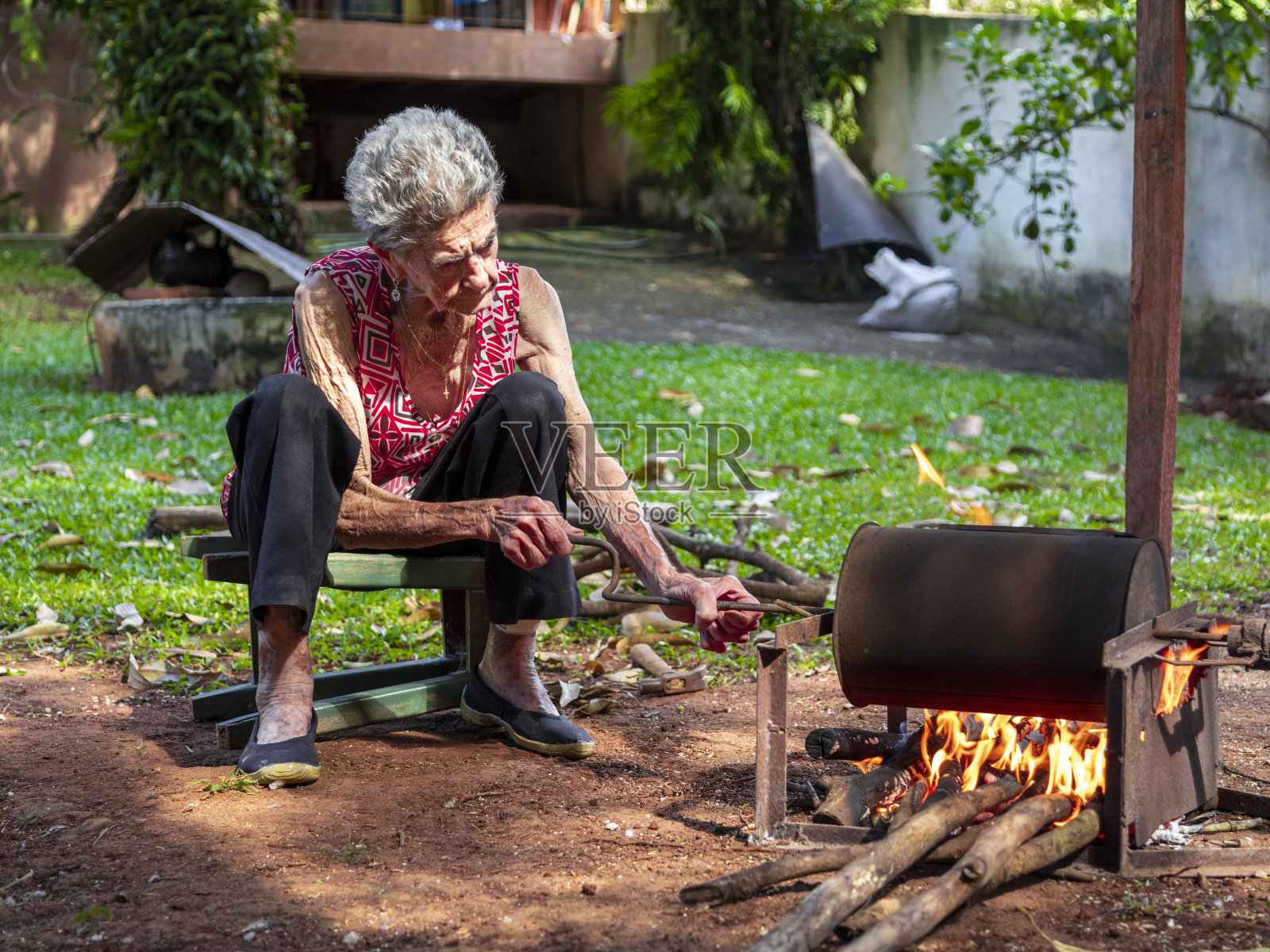 老妇人手工烘焙咖啡，就像她在农场做的那样照片摄影图片