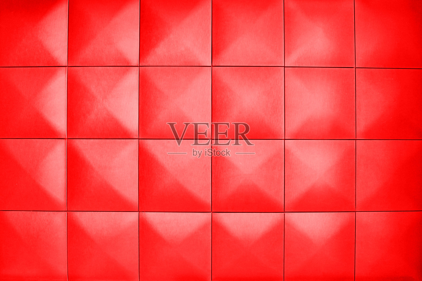 菱形的浅红色大正方形墙。背景由大的浅红色方块组成。不寻常，美丽和现代的背景。照片摄影图片