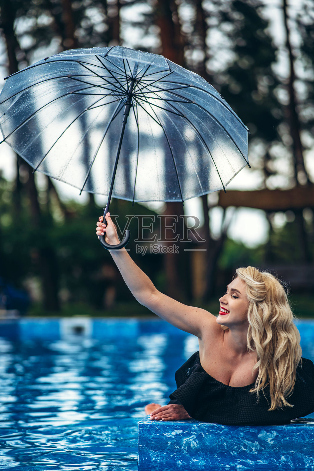 漂亮的别针风格的金发在黑色复古泳衣放松在游泳池照片摄影图片