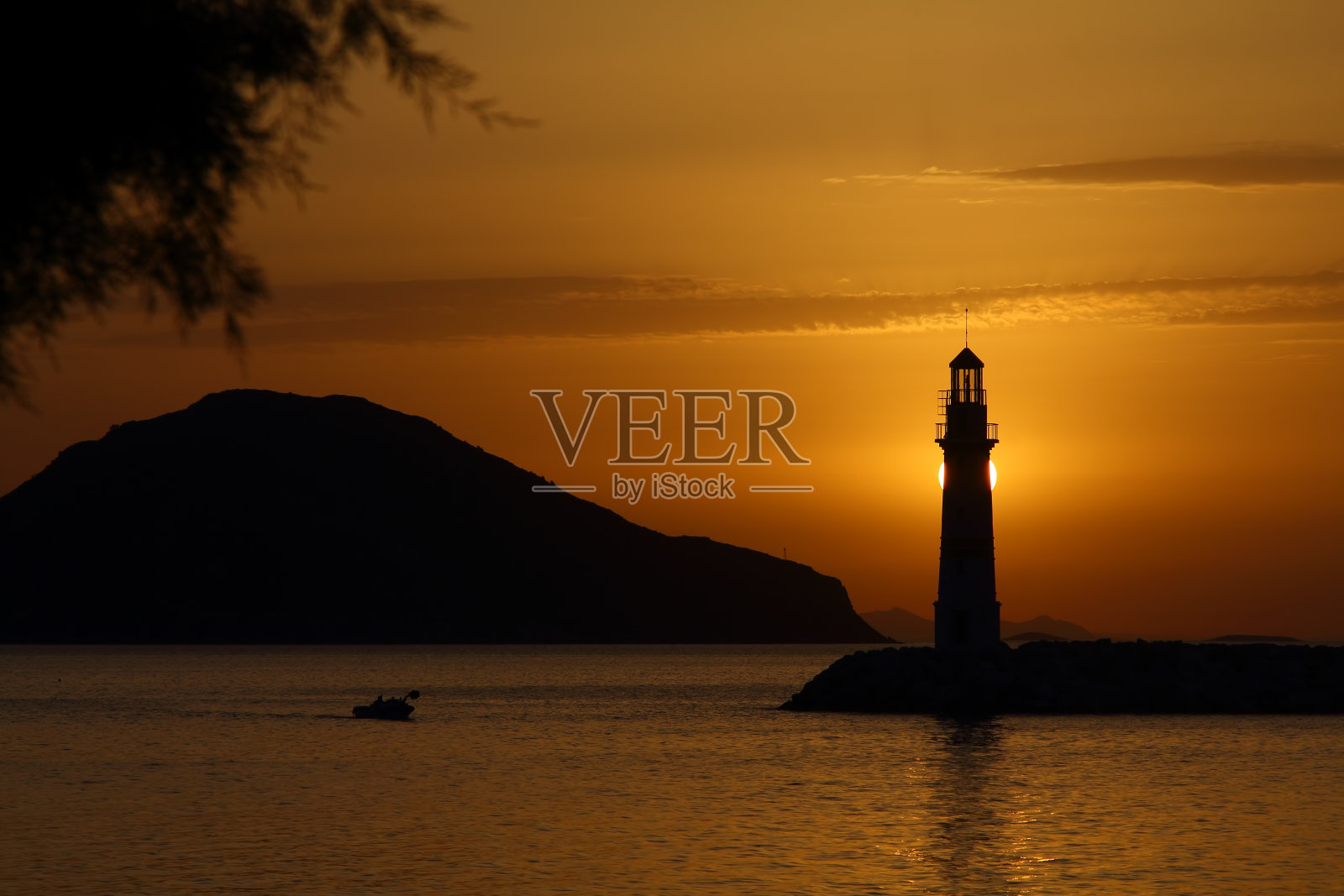 在夕阳海景。海岸上的灯塔。海边小镇Turgutreis和壮观的日落照片摄影图片