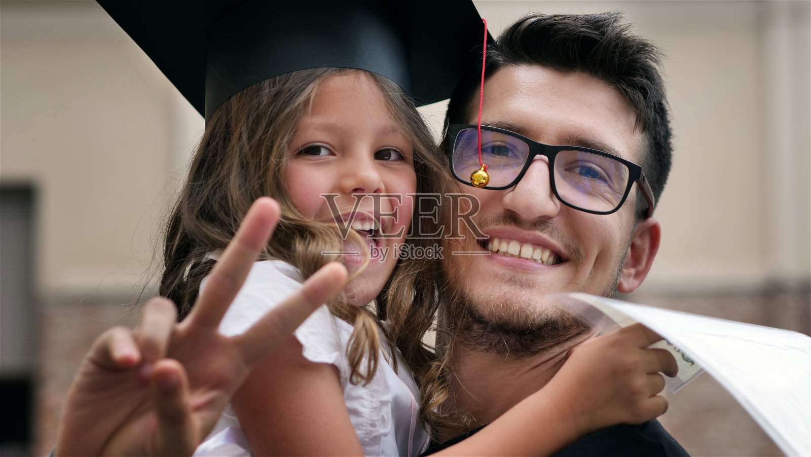 真实的小女孩与毕业帽后视图在仪式。照片摄影图片