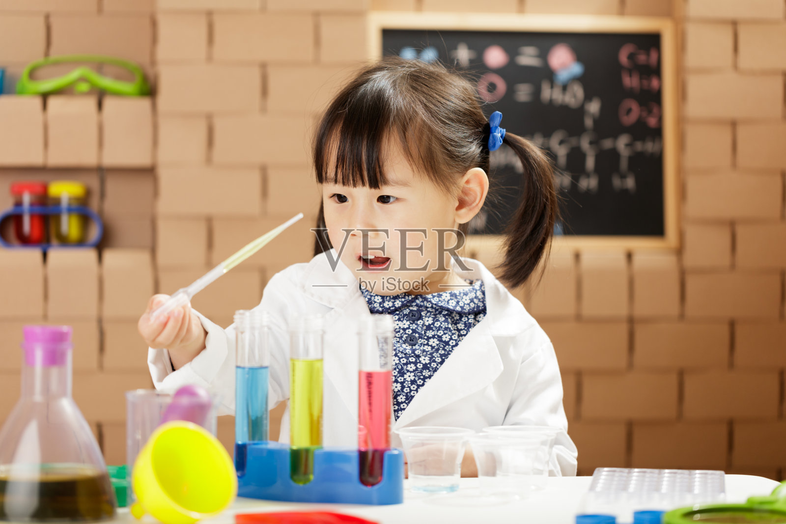 蹒跚学步的女孩假装扮演科学家角色在家上学照片摄影图片