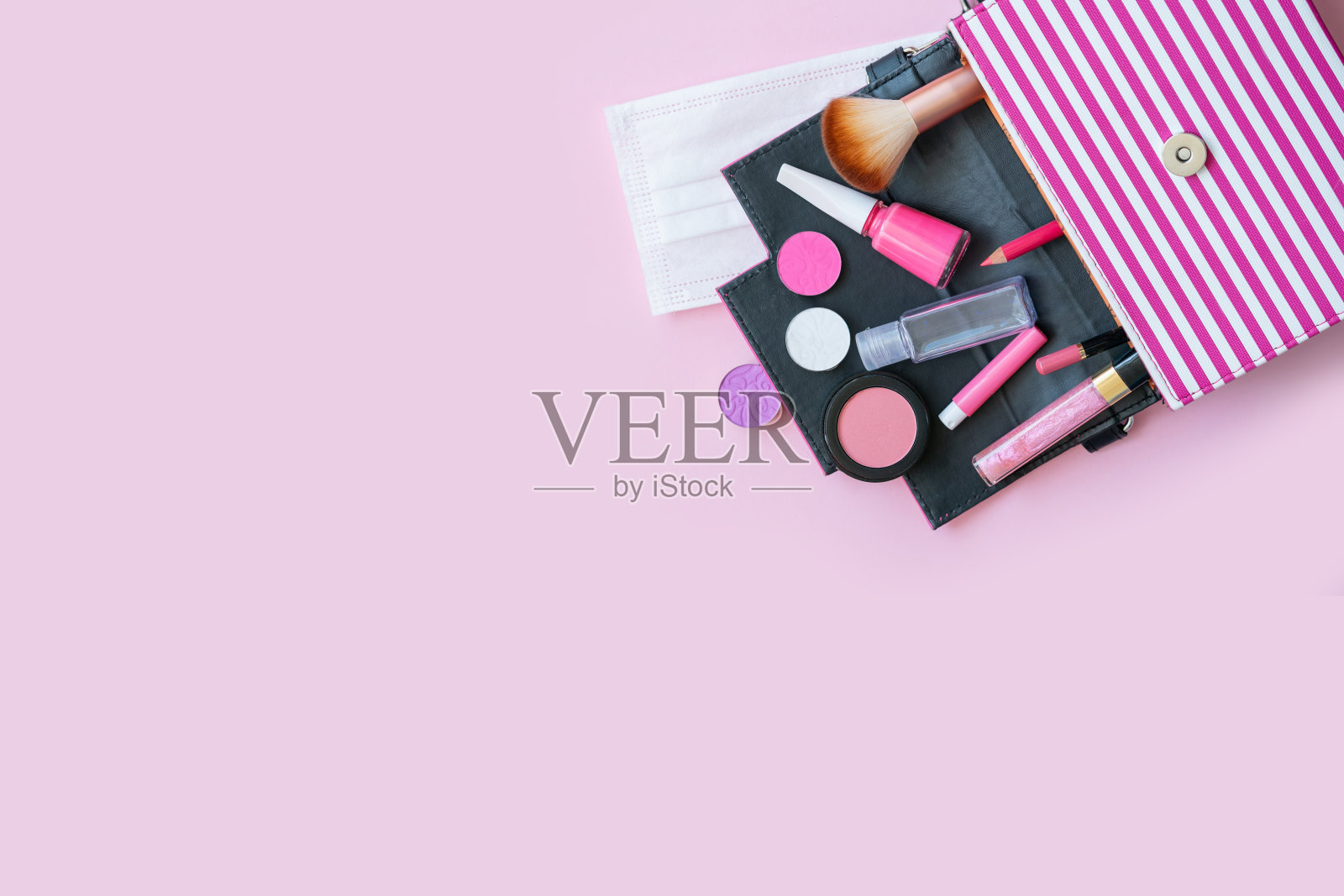 女式粉色化妆包:眼影，唇彩，指甲油，腮红，刷子，面膜和消毒液照片摄影图片