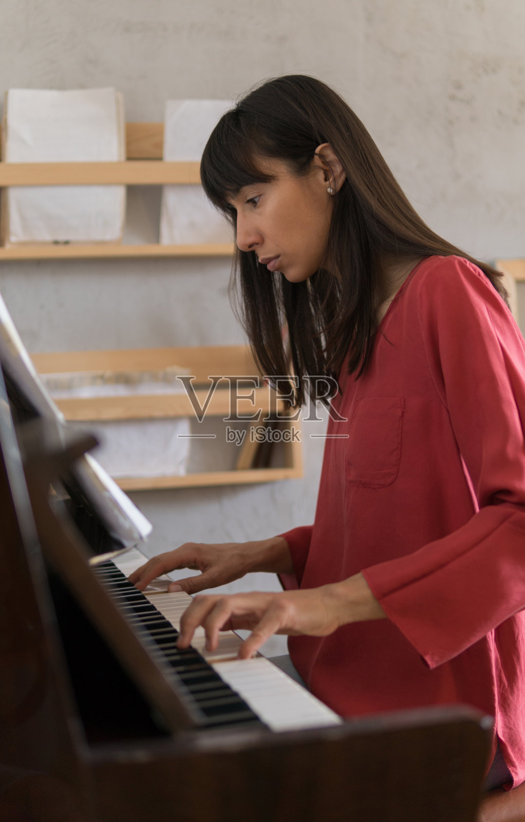 美丽的年轻女子在家里弹钢琴照片摄影图片