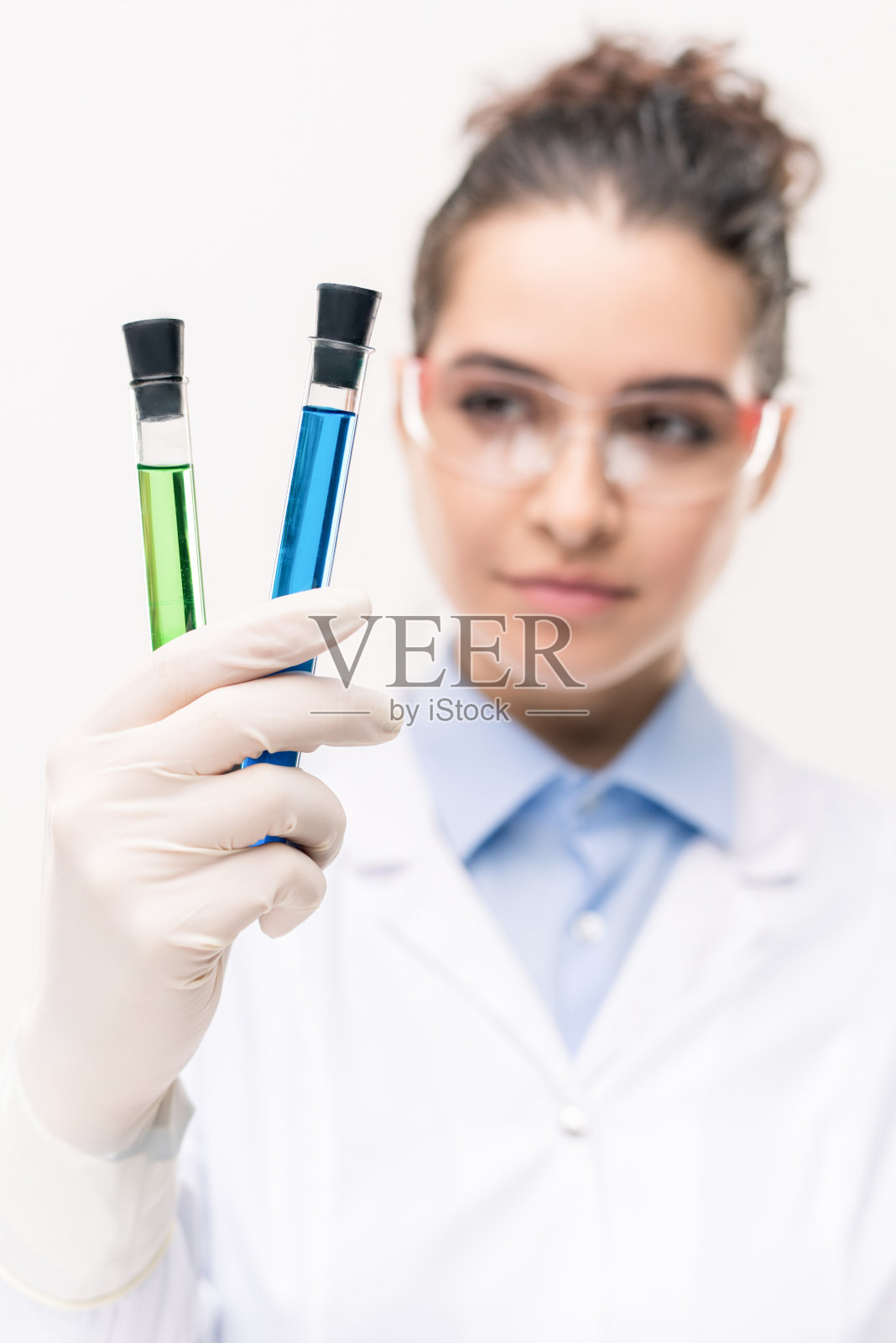 女性临床医生或科学家手持两个装有液体疫苗的烧瓶照片摄影图片