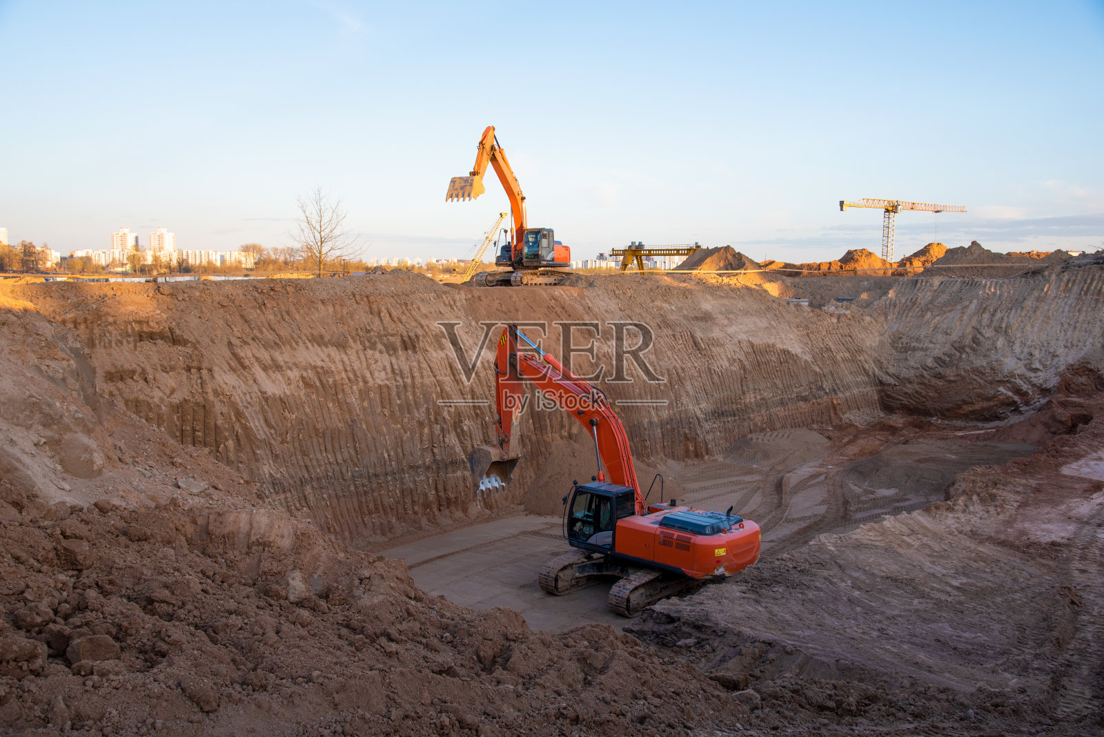 用挖掘机挖坑地基。在开挖和回填土到要求的深度的土方工程，以建设壕沟。照片摄影图片