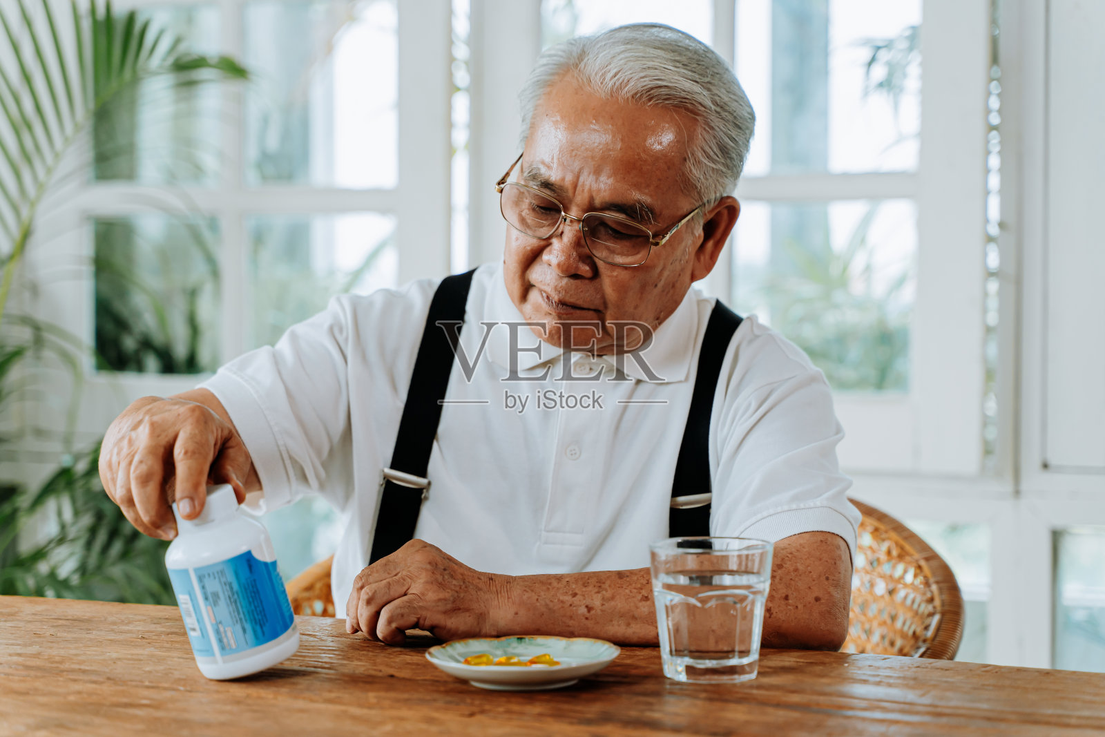 年长的亚洲男人在吃药照片摄影图片