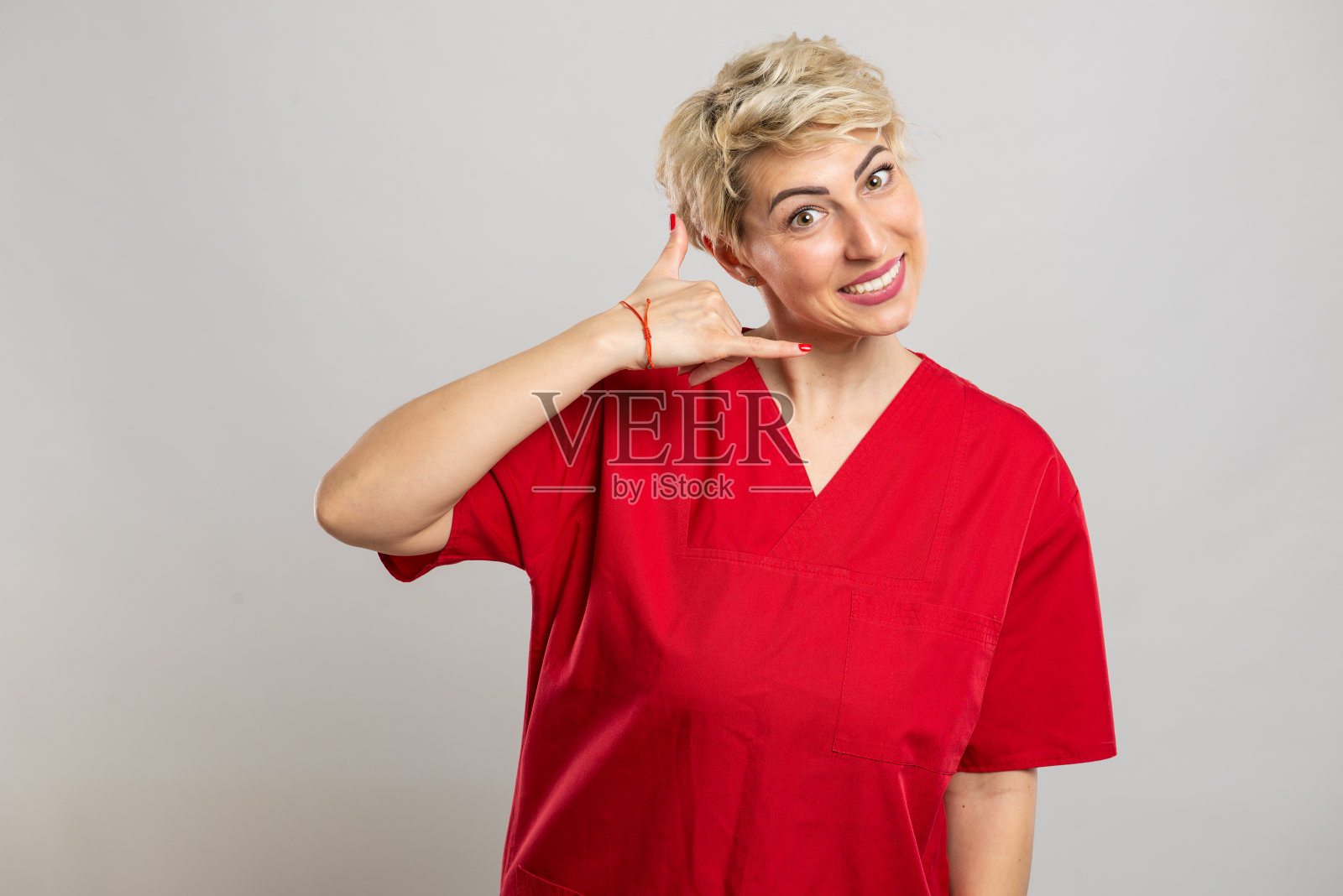 年轻迷人的女护士做呼叫手势的肖像照片摄影图片