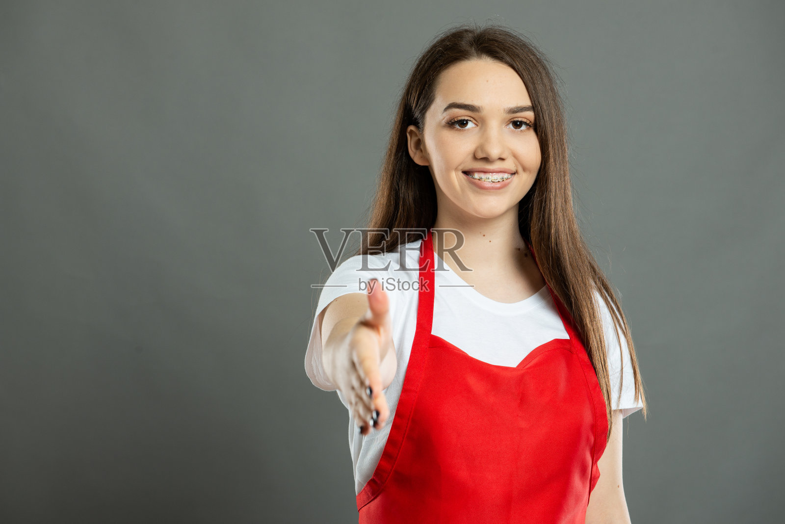 年轻的女超市员工提供握手的肖像照片摄影图片