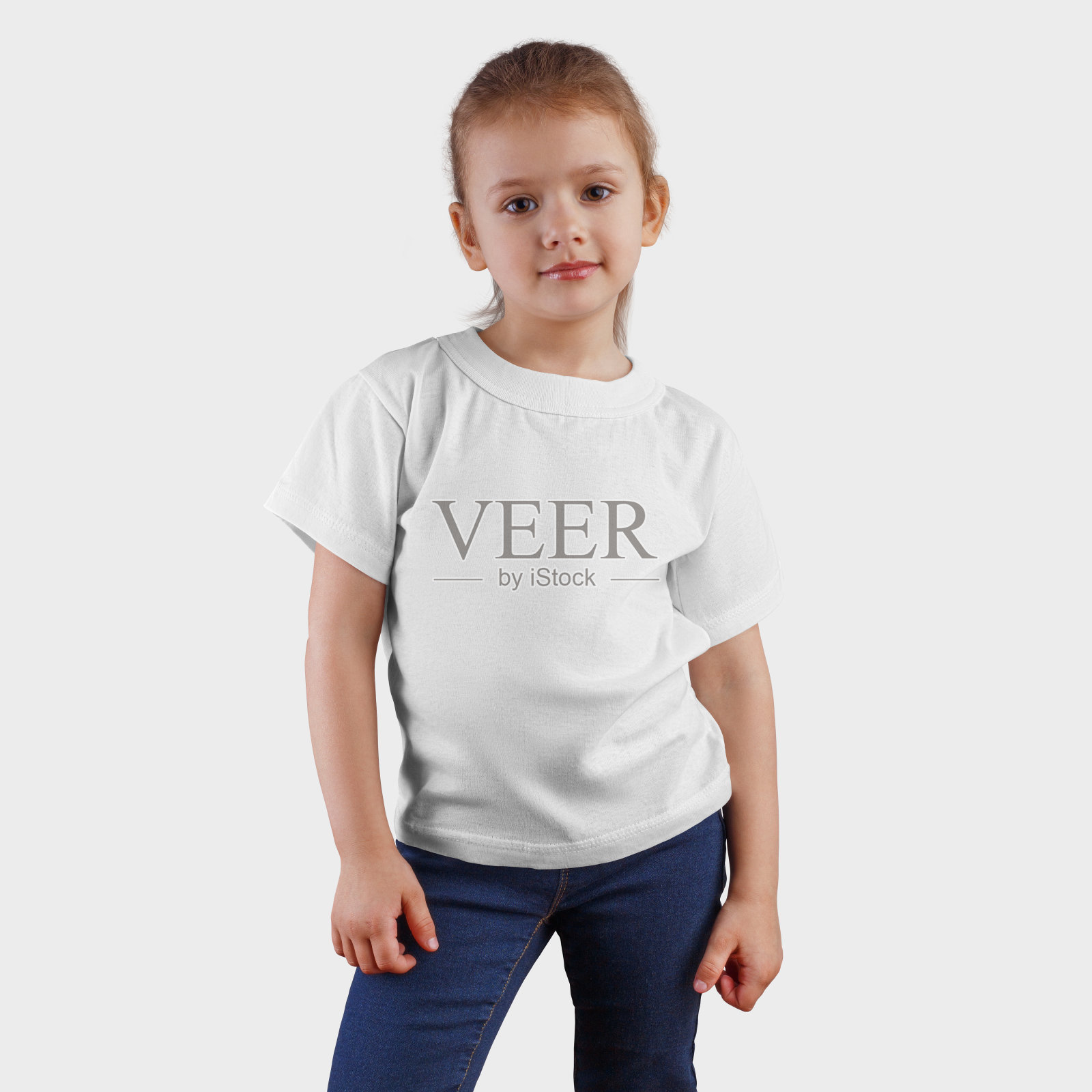 白色t恤的模型在一个微笑的孩子在蓝色牛仔裤，展示的儿童服装的设计和模式。照片摄影图片