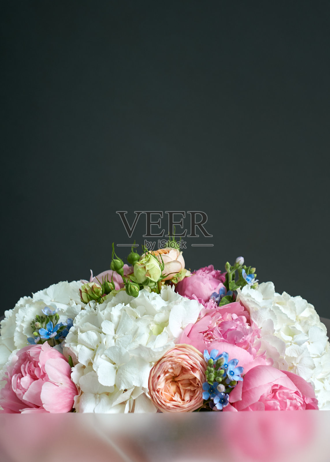 一束白、粉、黄相间的花。花有绣球、牡丹、玫瑰。照片摄影图片