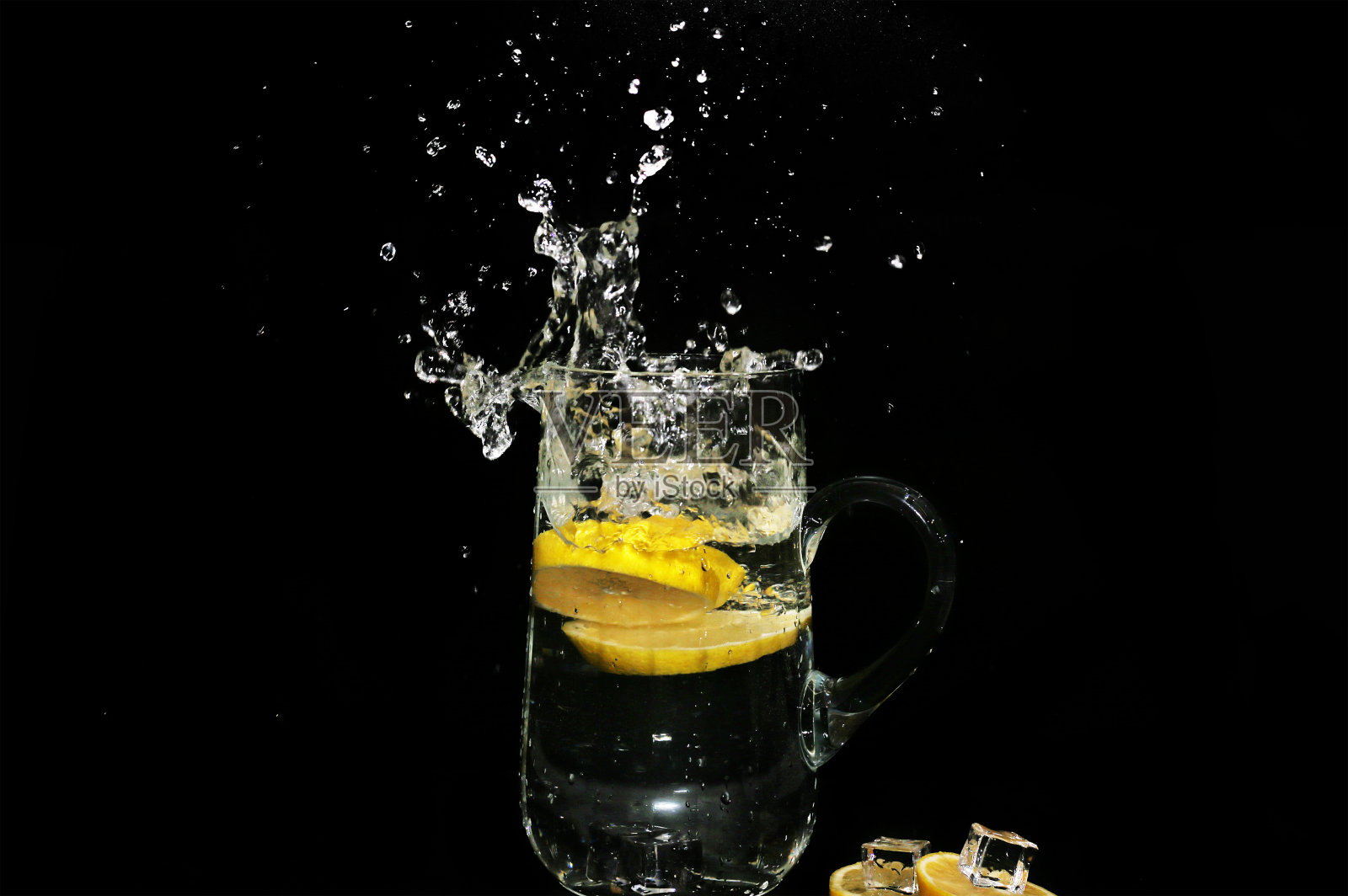冰水飞溅与柠檬片孤立的黑色背景-高速摄影照片摄影图片