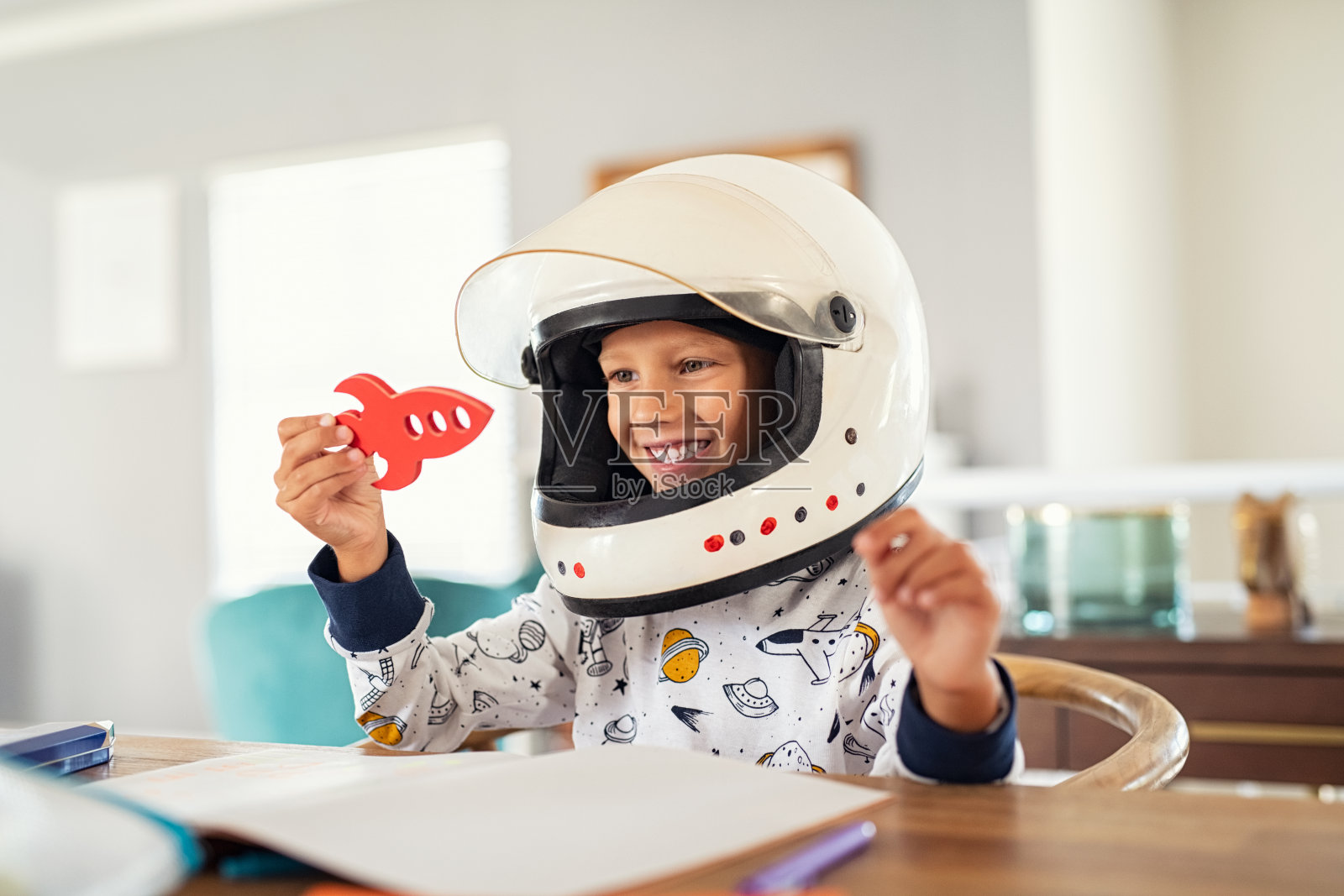 孩子在玩宇航员头盔和火箭照片摄影图片