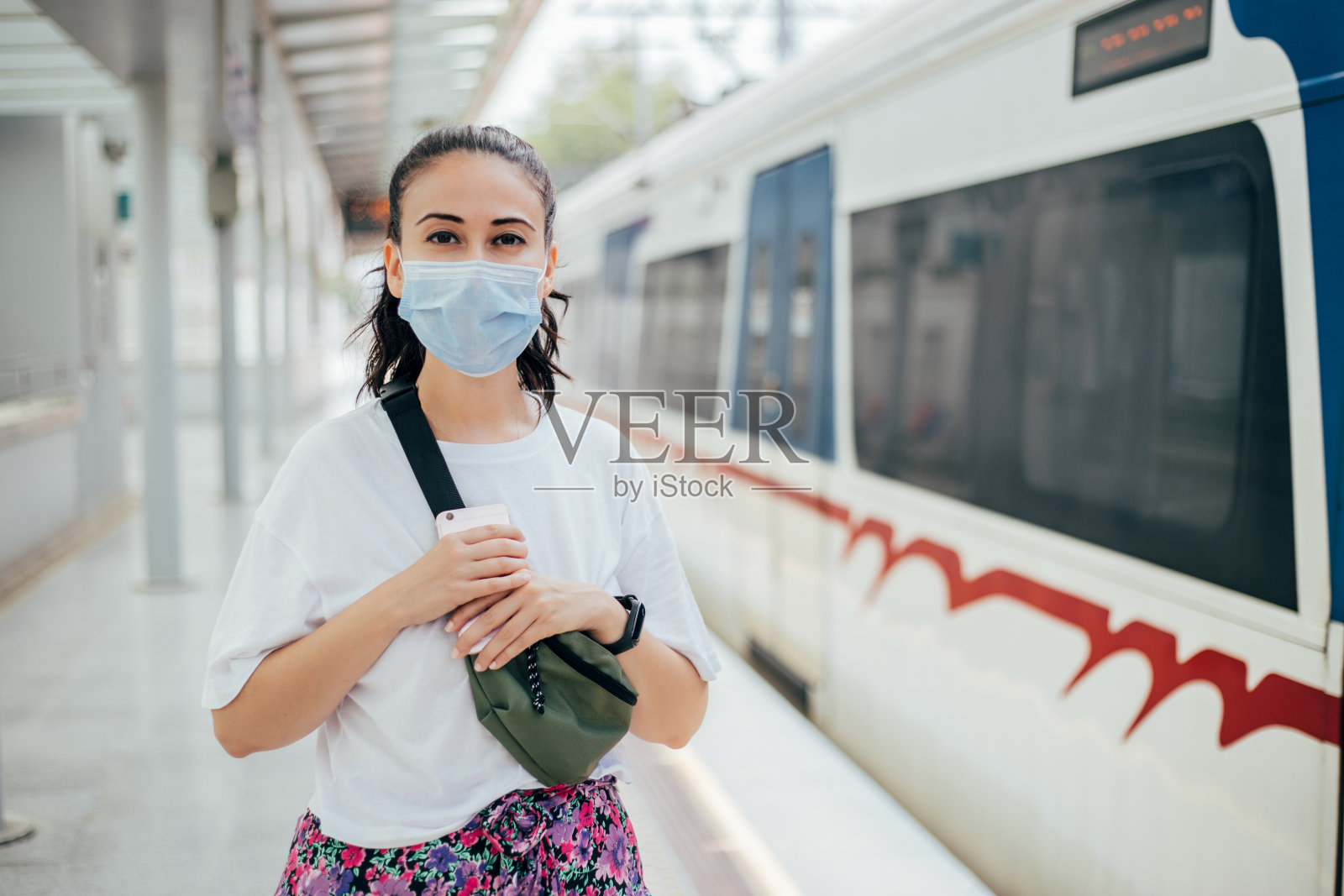 戴着消毒口罩的妇女在火车站等候照片摄影图片
