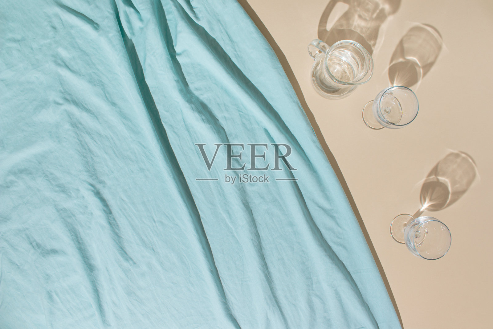 明亮的蓝色沙滩毛巾，眼镜和水壶的夏日场景。冷饮或茶点概念。照片摄影图片