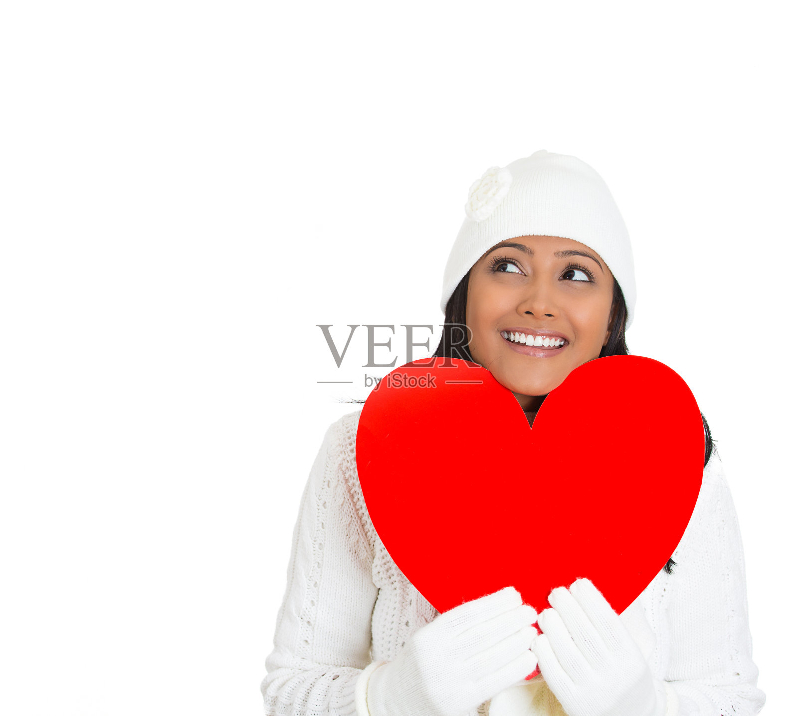 肖像的年轻漂亮的女人穿着冬天的装备，穿着毛衣拿着红色的情人心照片摄影图片