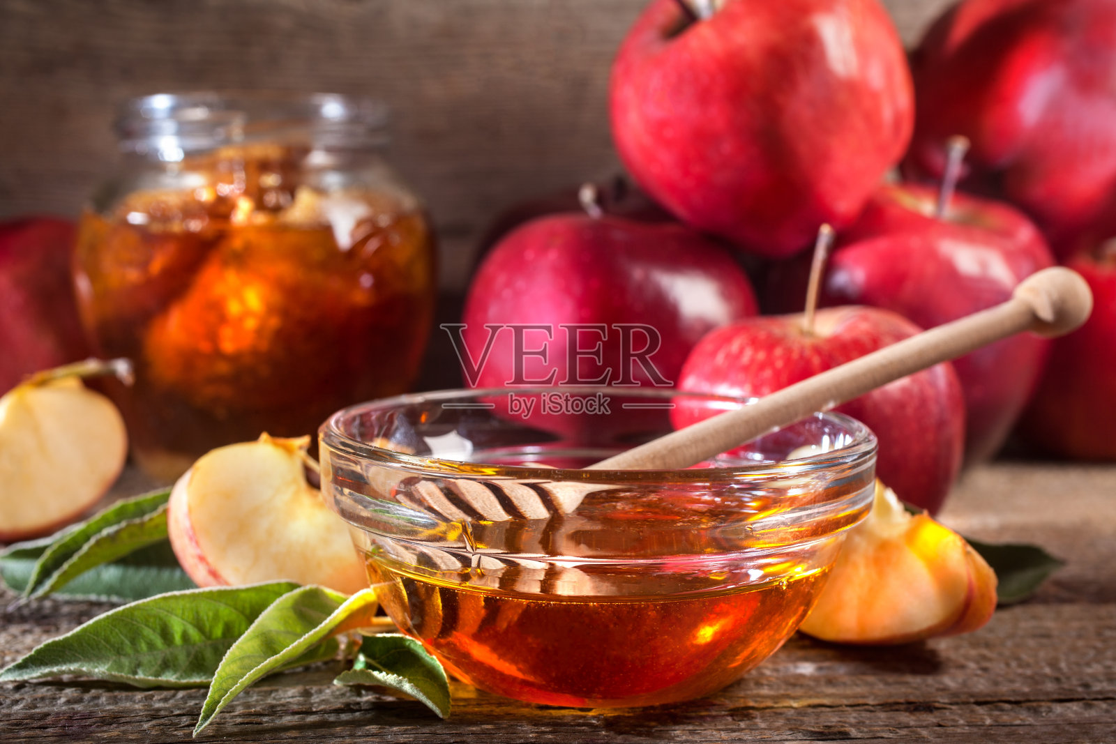 苹果和蜂蜜放在质朴的木桌上照片摄影图片