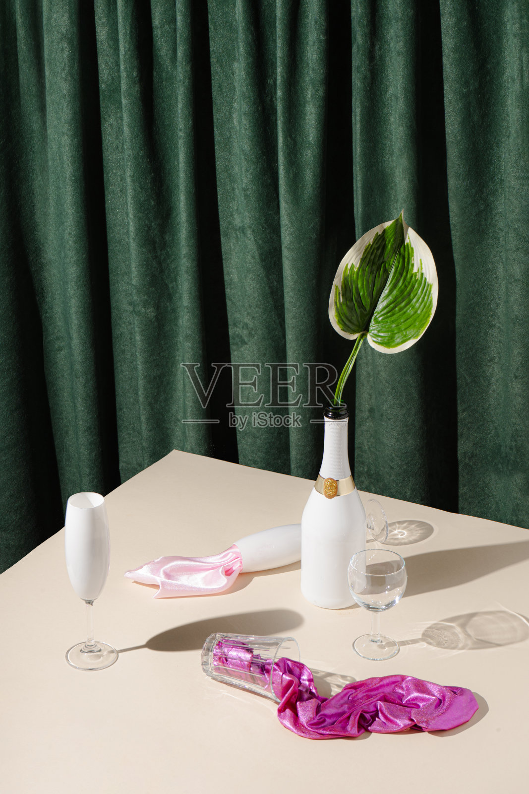 复古风格概念香槟瓶，眼镜，粉色织物和棕榈叶。照片摄影图片