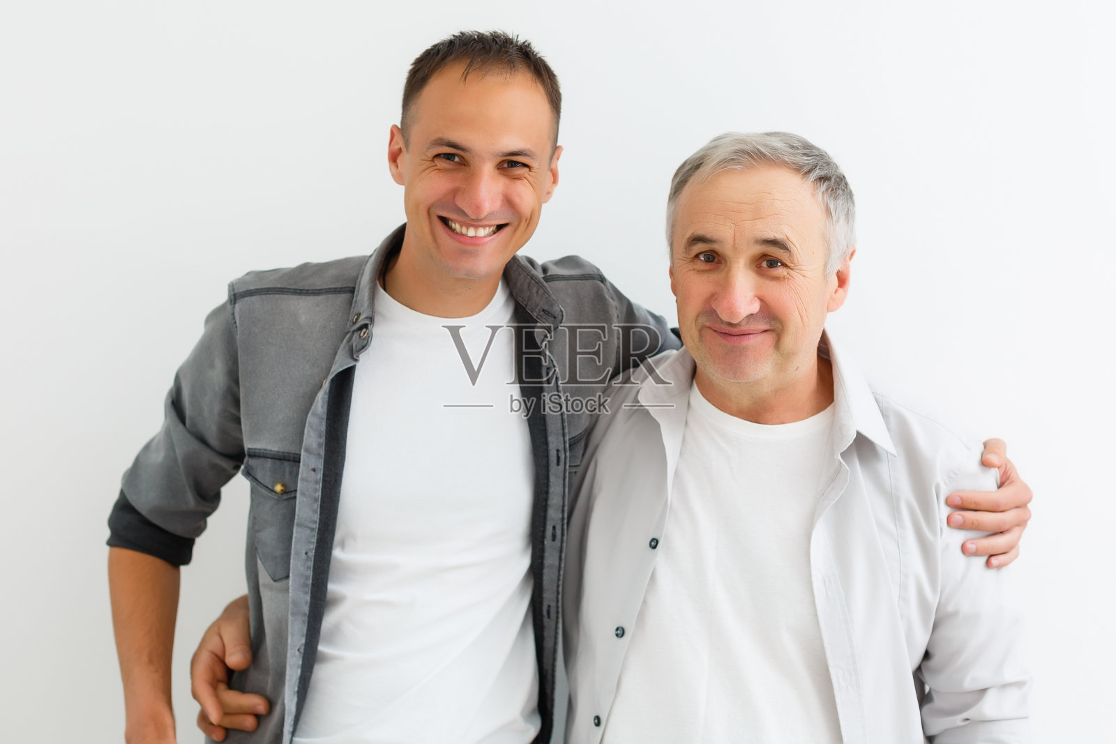 年长的父亲和成年的儿子在一个白色的背景照片摄影图片