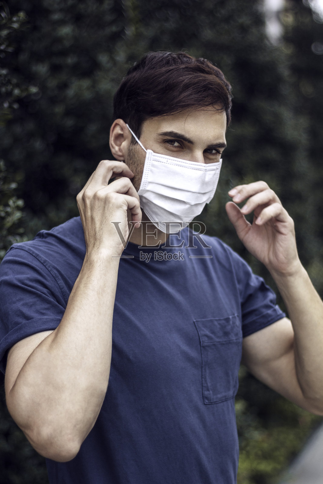 男子戴着外科口罩，保护自己免受冠状病毒感染照片摄影图片