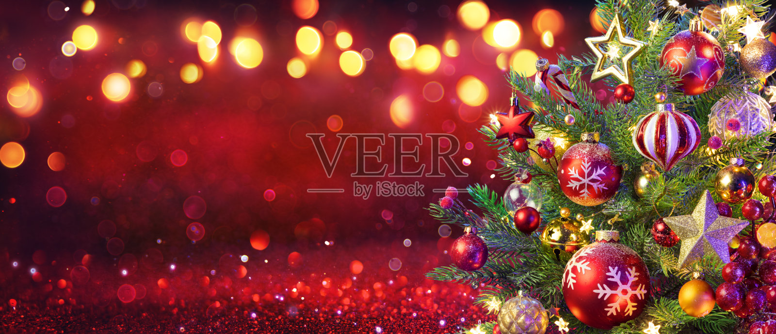 抽象圣诞树与装饰品和散景灯在红色闪烁的背景照片摄影图片