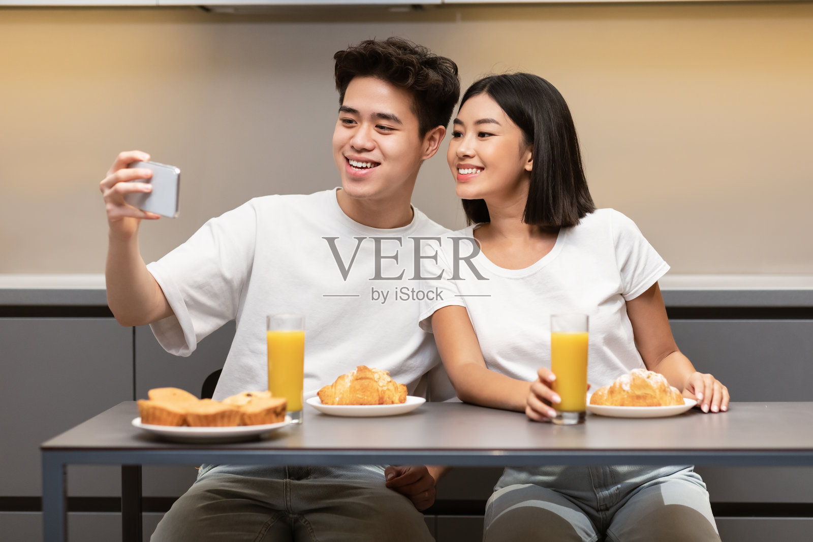 韩国丈夫与妻子在厨房吃早餐时自拍照片摄影图片