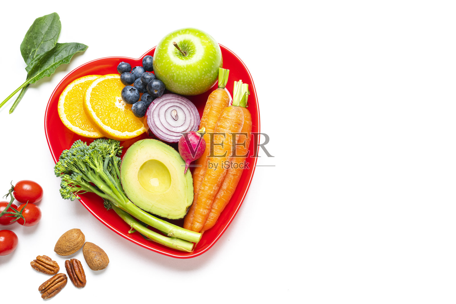红色的心型盘子，健康的水果和蔬菜放在白色的桌子上。本空间照片摄影图片