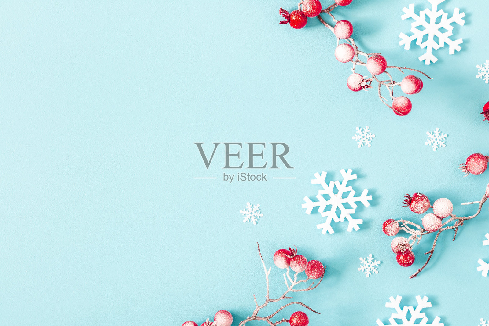 圣诞节或冬天的作文。蓝色背景下的雪花和红浆果。圣诞节，冬天，新年的概念。平躺，俯视图照片摄影图片