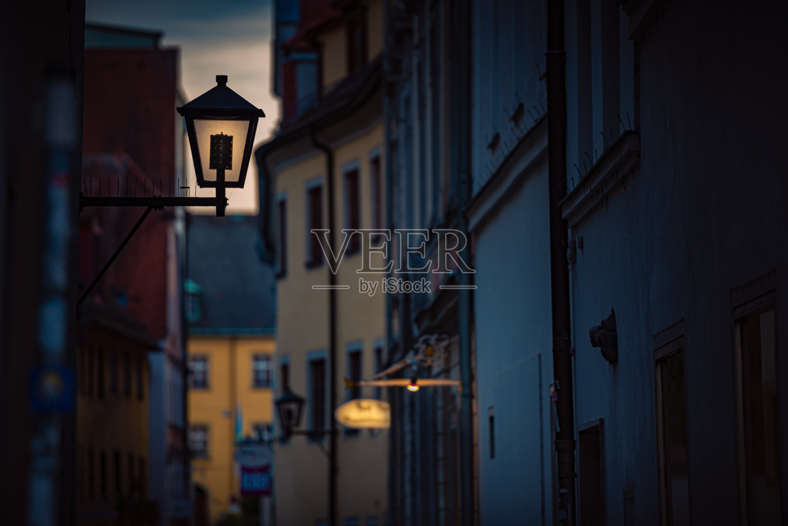 老城区的景色与黄昏在狭窄的小巷和日落天空的背景。德国，巴伐利亚，欧洲旅行。照片摄影图片