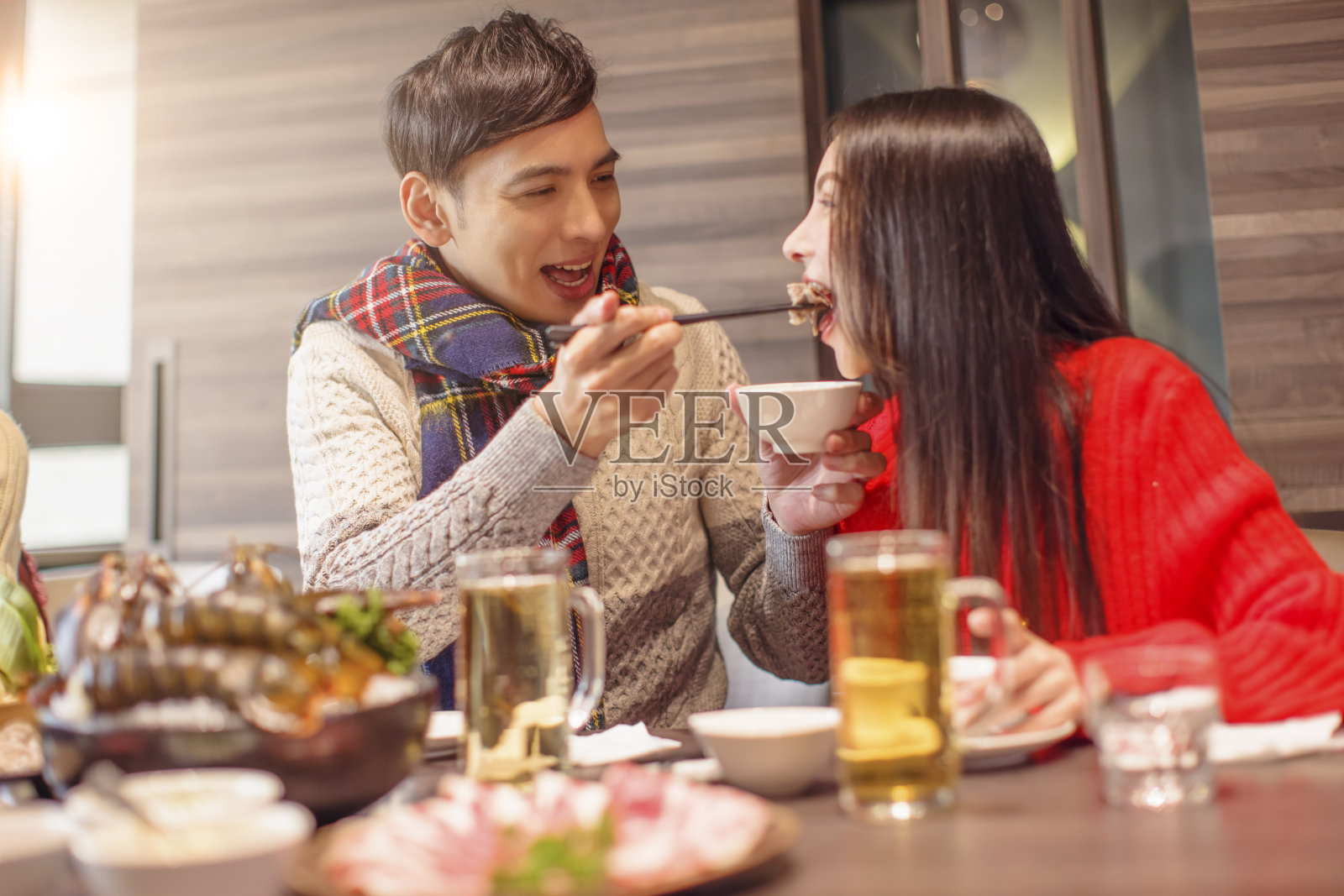 一个年轻人正在餐馆喂他的女朋友照片摄影图片