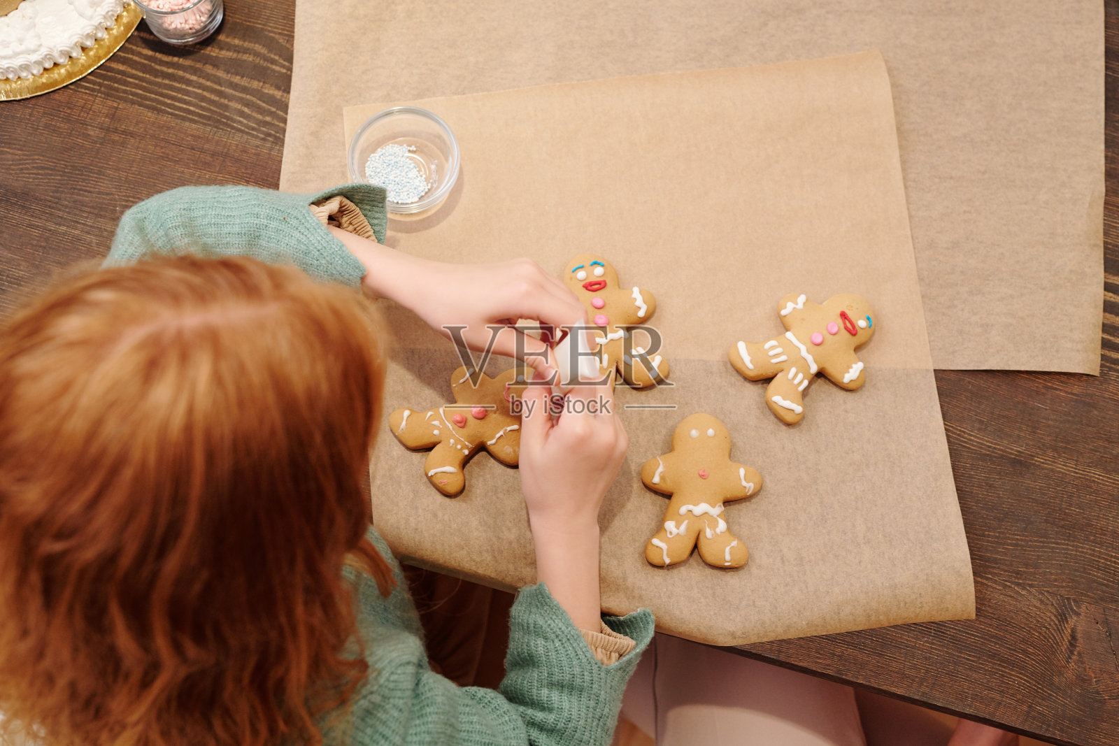 可爱的小女孩用白釉装饰自制的姜饼照片摄影图片