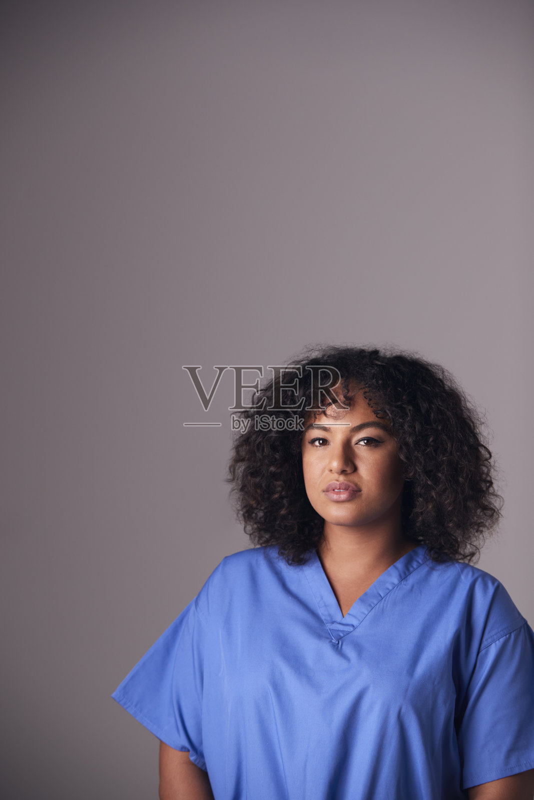 女护士穿着手术服站在灰色背景下的工作室肖像照片摄影图片