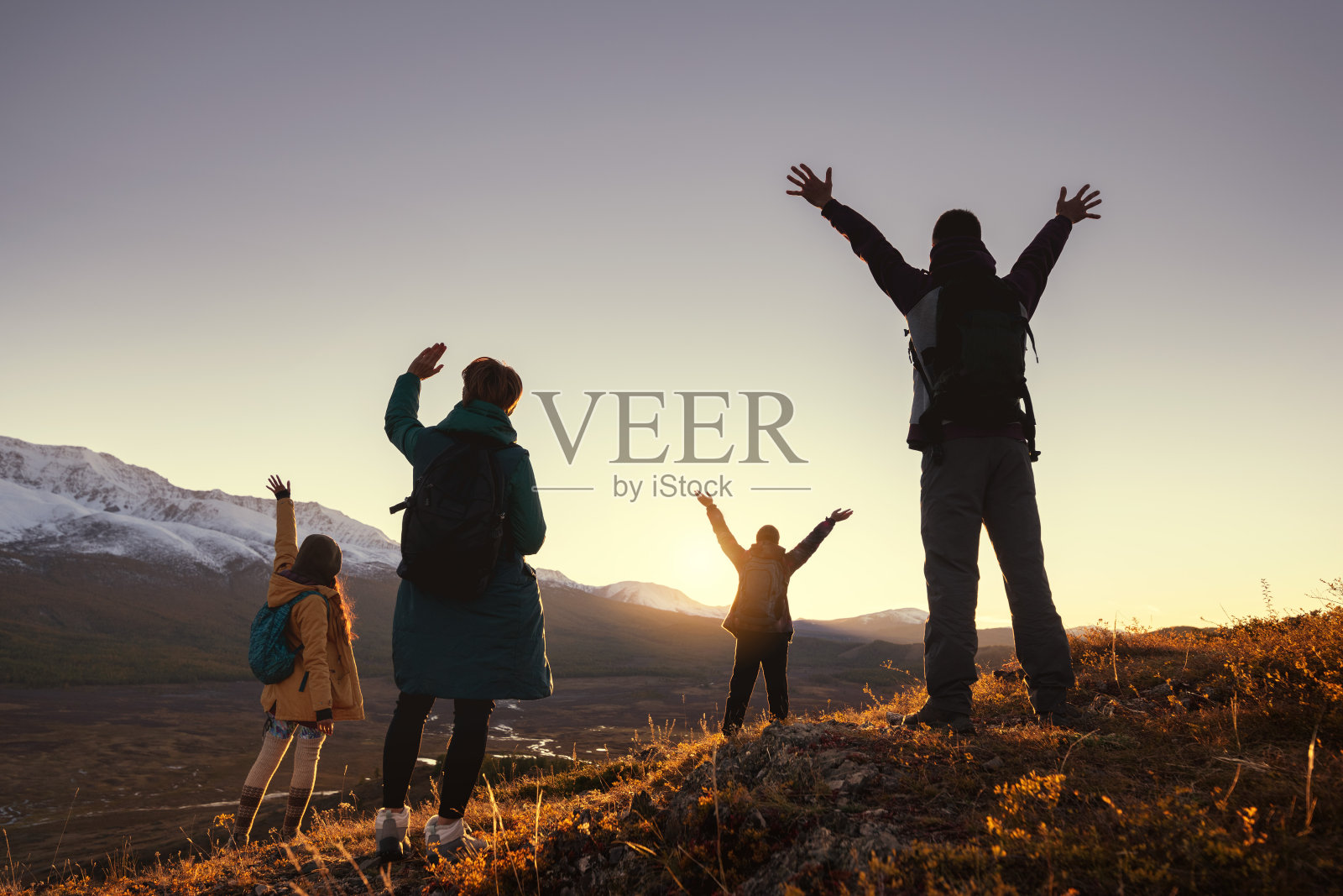 四个年轻的徒步旅行者在山上迎接日落照片摄影图片
